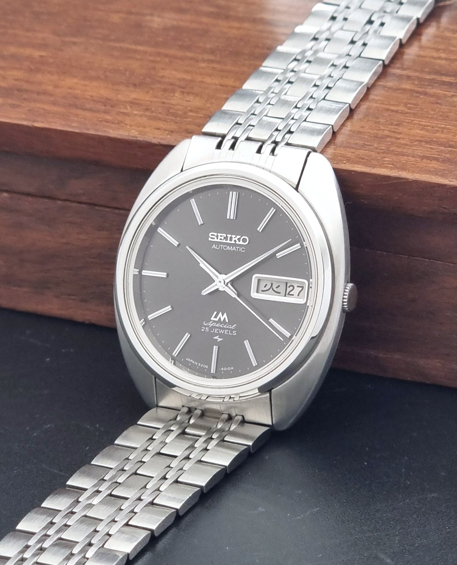 Vintage Seiko watch LordMatic Special 5206-6030 with a stainless steel bracelet on a dark background crown view