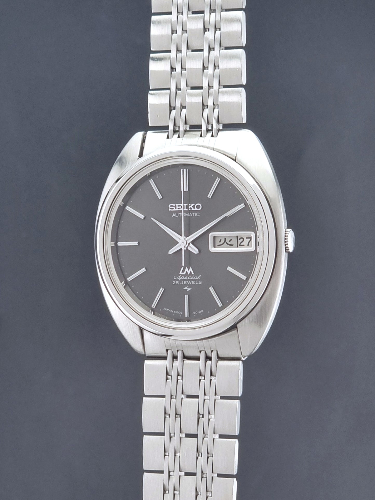 Vintage Seiko watch LordMatic Special 5206-6030 with a stainless steel bracelet on a dark background crown profile view