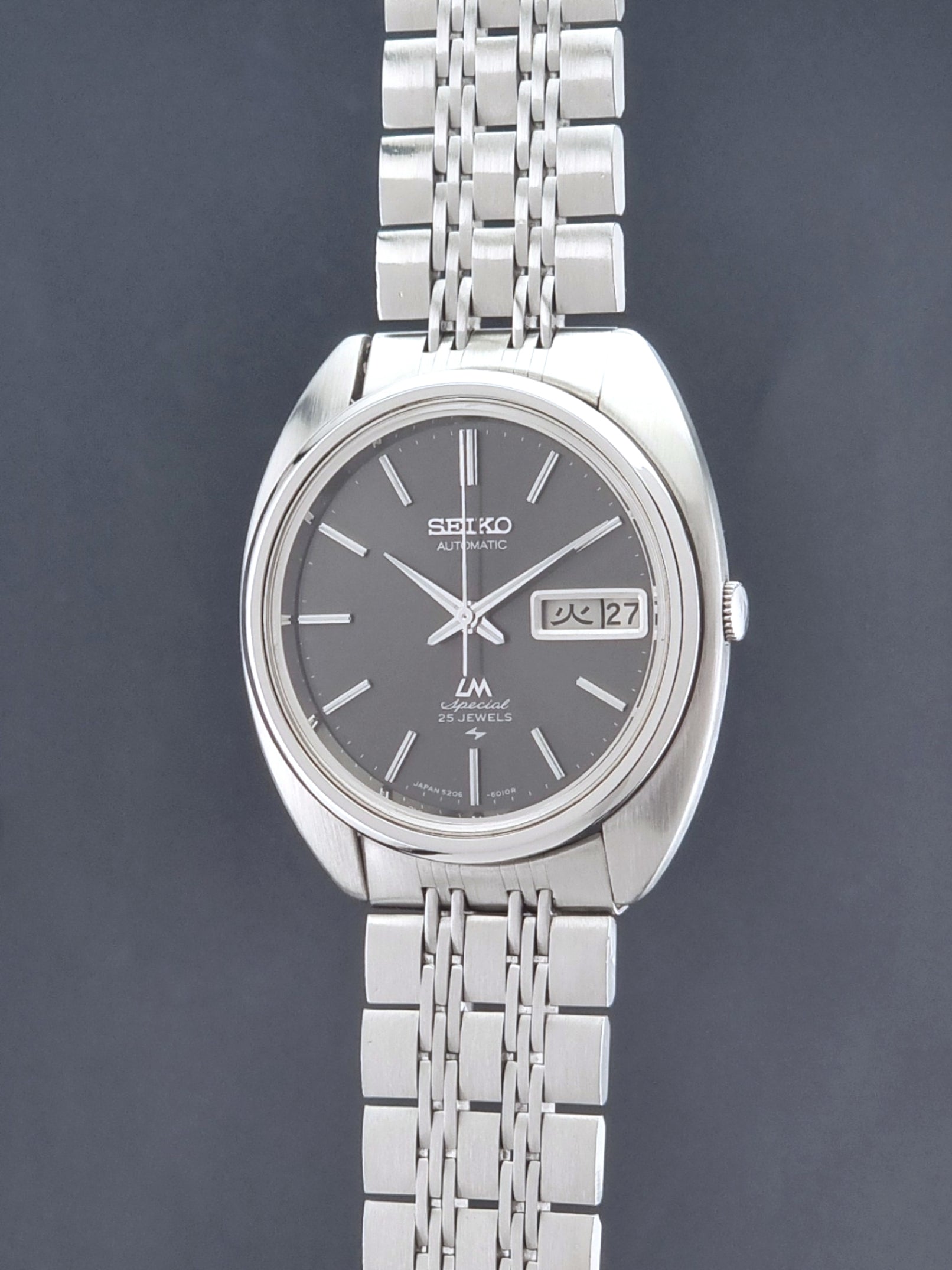 Vintage Seiko watch LordMatic Special 5206-6030 with a stainless steel bracelet on a dark background crown profile view