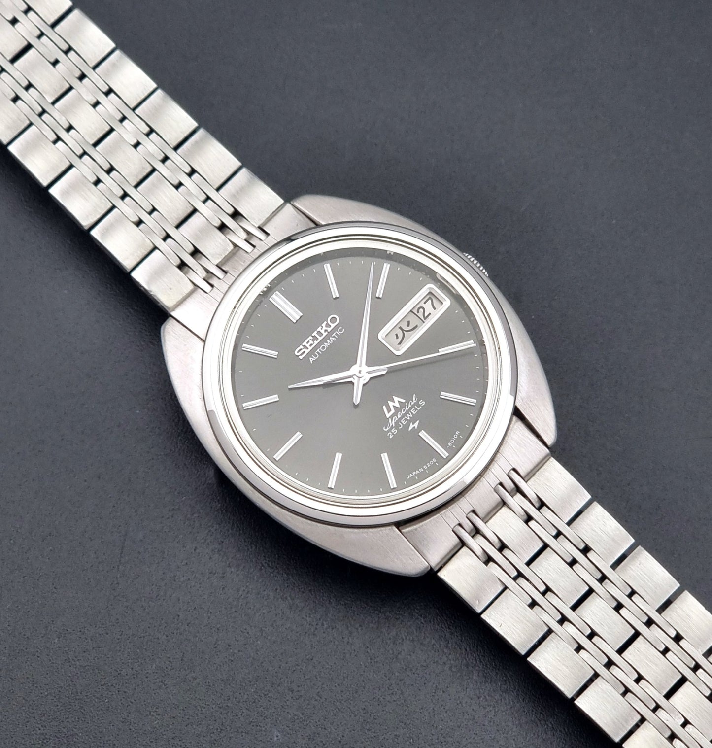 Vintage Seiko watch LordMatic Special 5206-6030 with a stainless steel bracelet on a dark background close up dial view