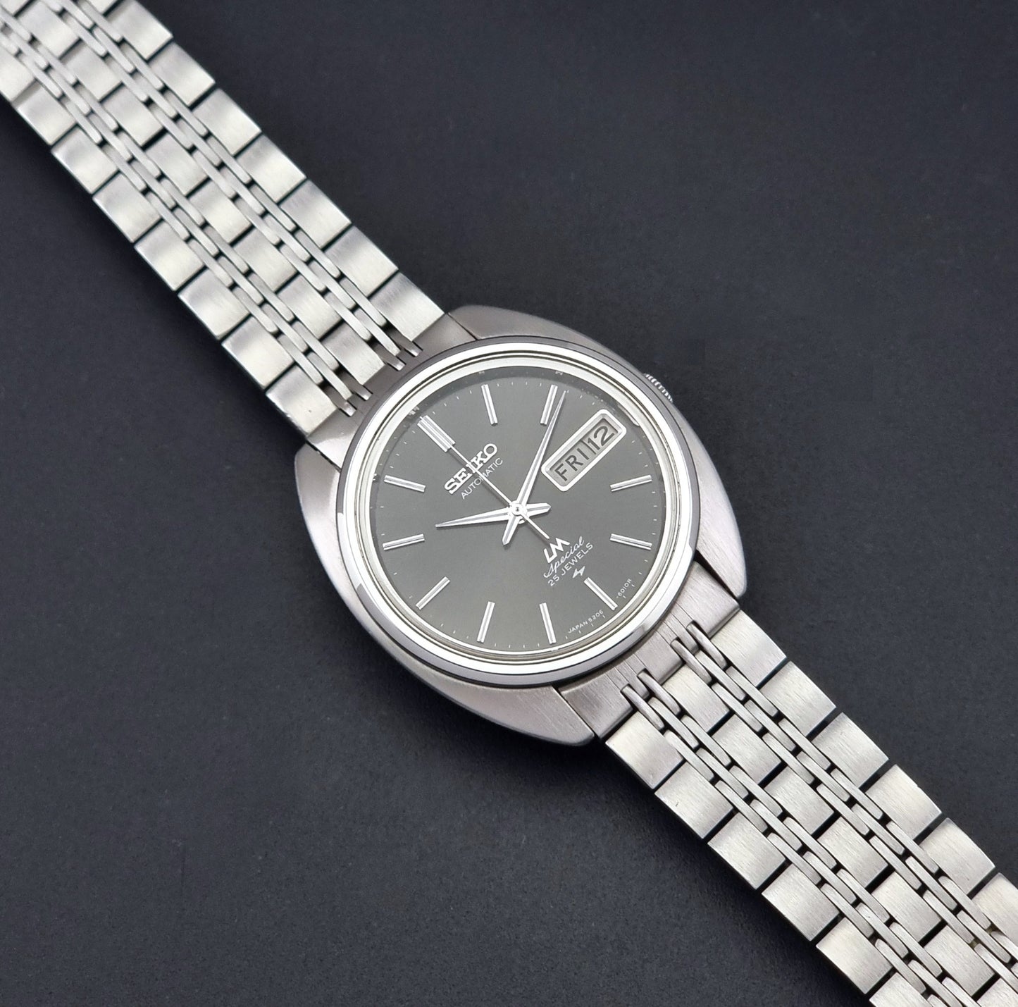 Vintage Seiko watch LordMatic Special 5206-6030 with a stainless steel bracelet on a dark background dial