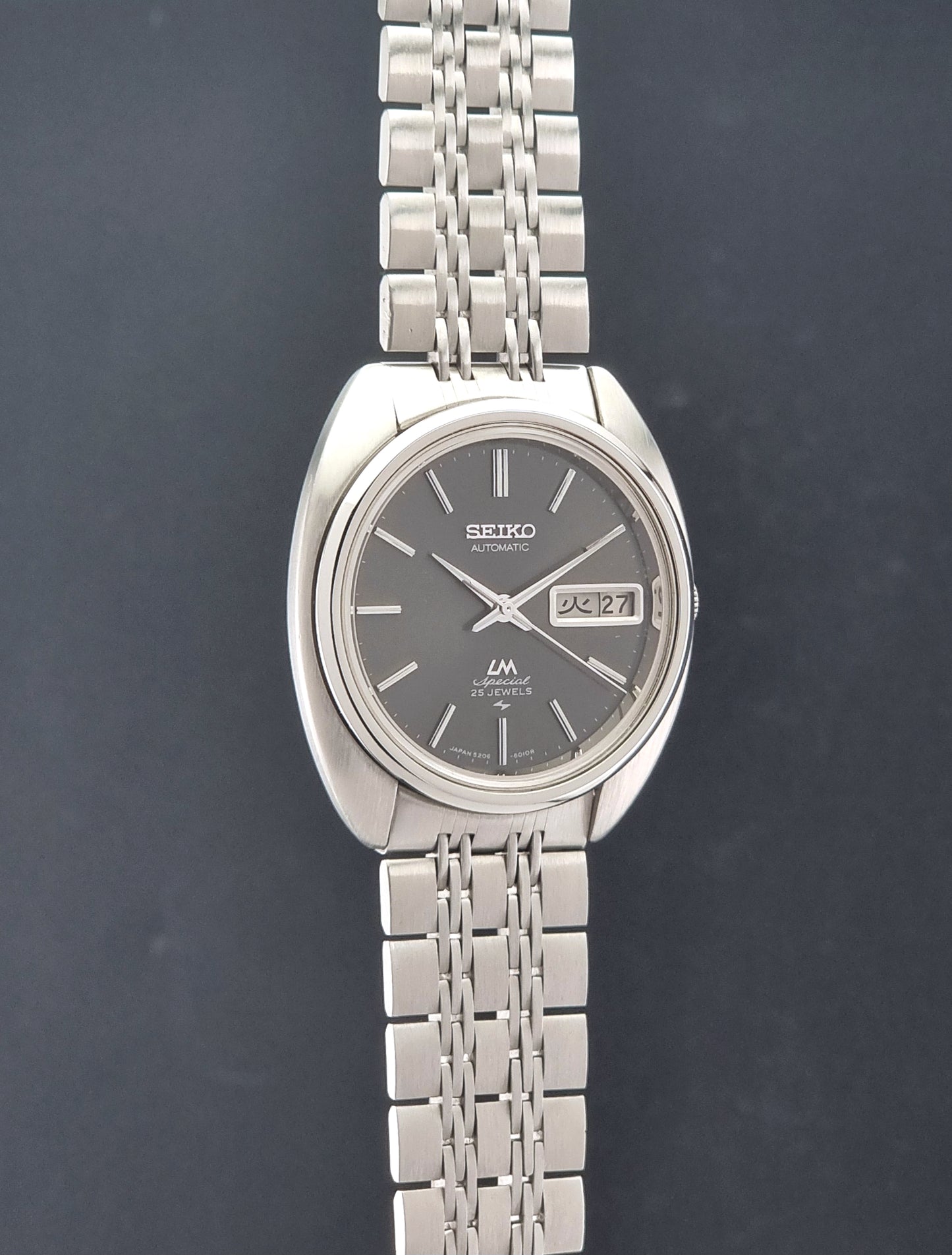 Vintage Seiko watch LordMatic Special 5206-6030 with a stainless steel bracelet on a dark background side profile view