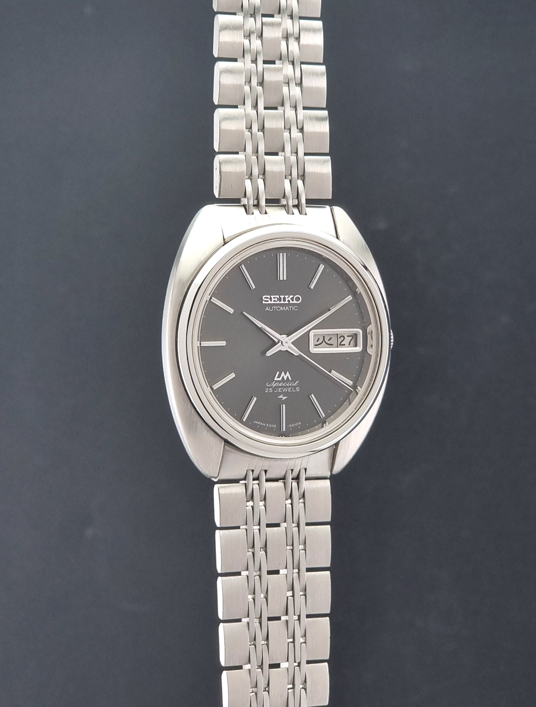 Vintage Seiko watch LordMatic Special 5206-6030 with a stainless steel bracelet on a dark background side profile view