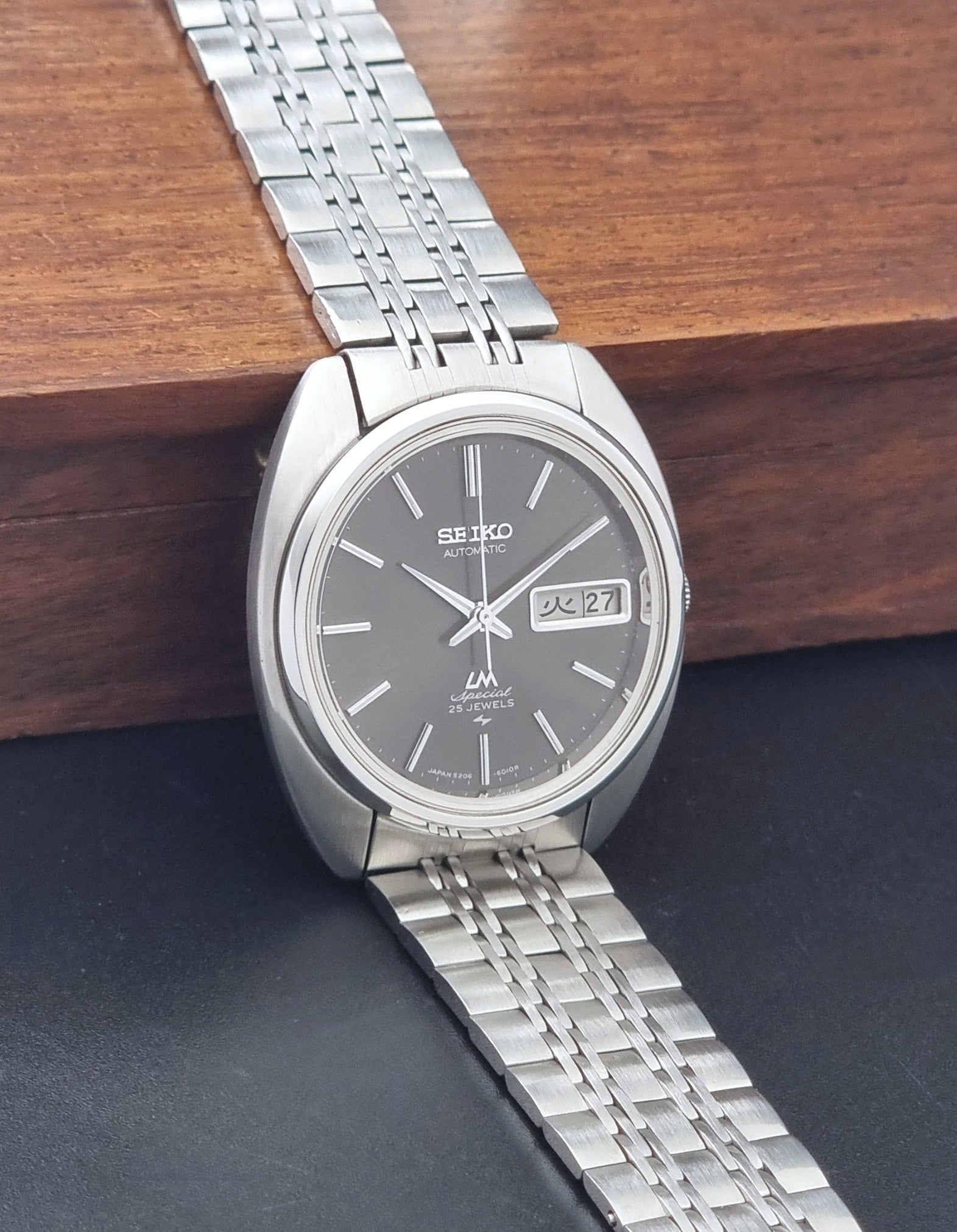 Vintage Seiko watch LordMatic Special 5206-6030 with a stainless steel bracelet on a dark background side view