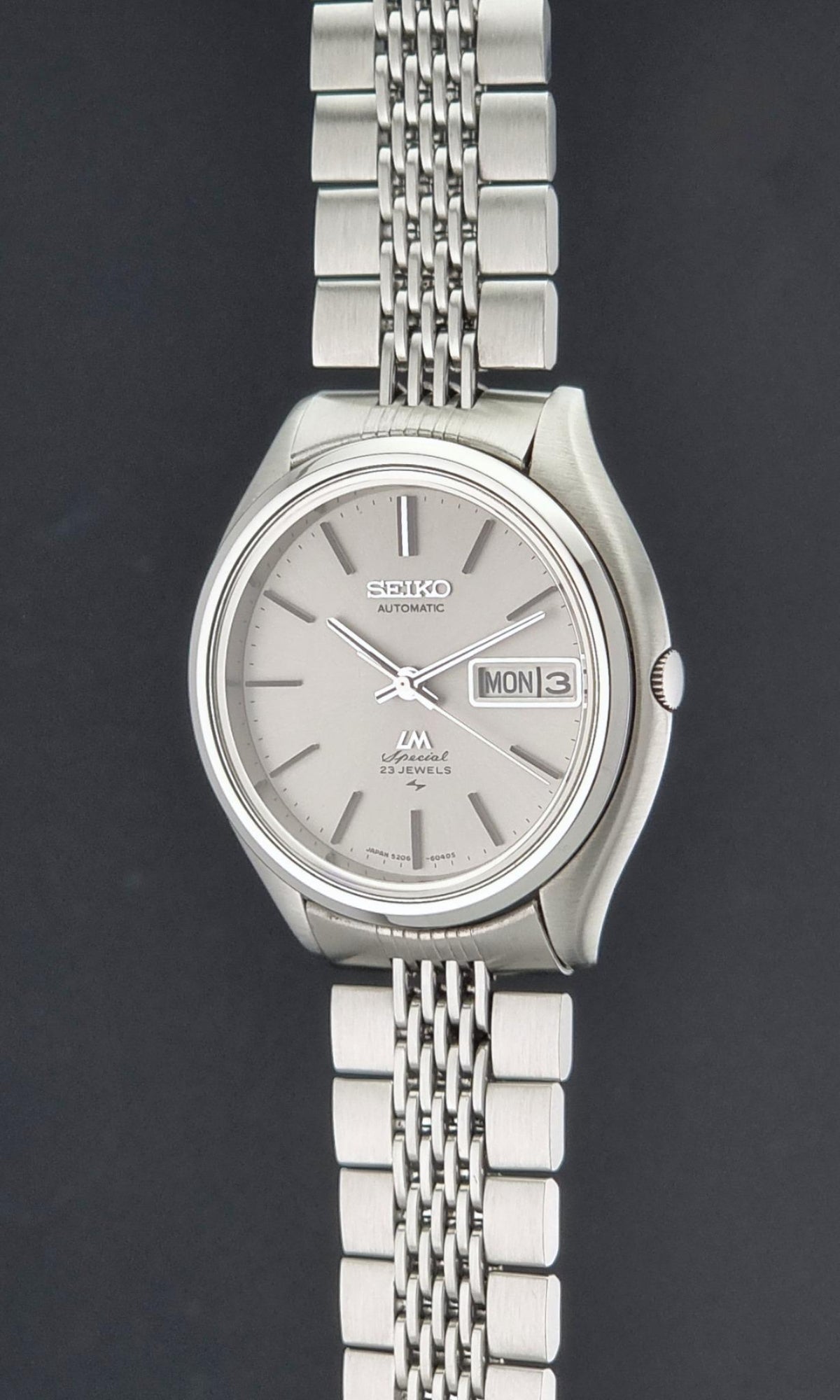 Vintage Seiko watch LordMatic Special 5206-6060 featuring a silver-toned stainless steel case and a matching multi-link bracelet, with a silver dial and a day-date window.