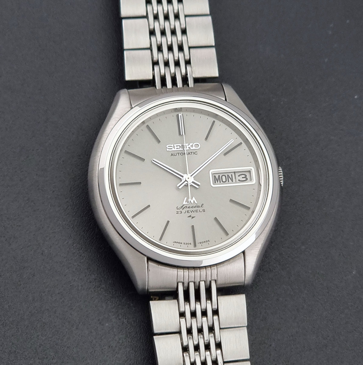 Vintage Seiko watch LordMatic Special 5206-6060 with a bracelet and grey sunburst dial on a dark background