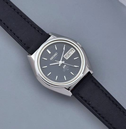 Vintage Seiko Lord Matic Special 5206-6080 watch with black leather strap on a gray background