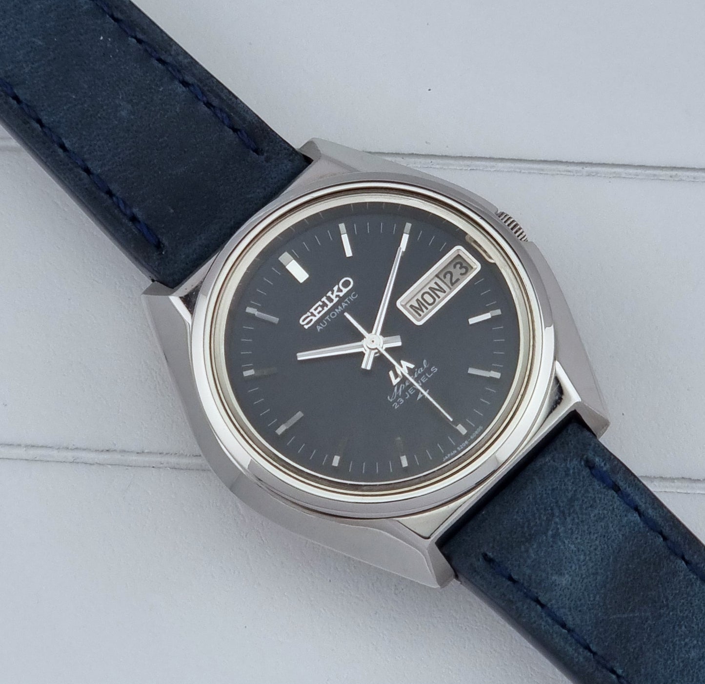 Vintage Seiko watch LordMatic Special 5206-6080 with blue strap and dark blue dial on a surface front view