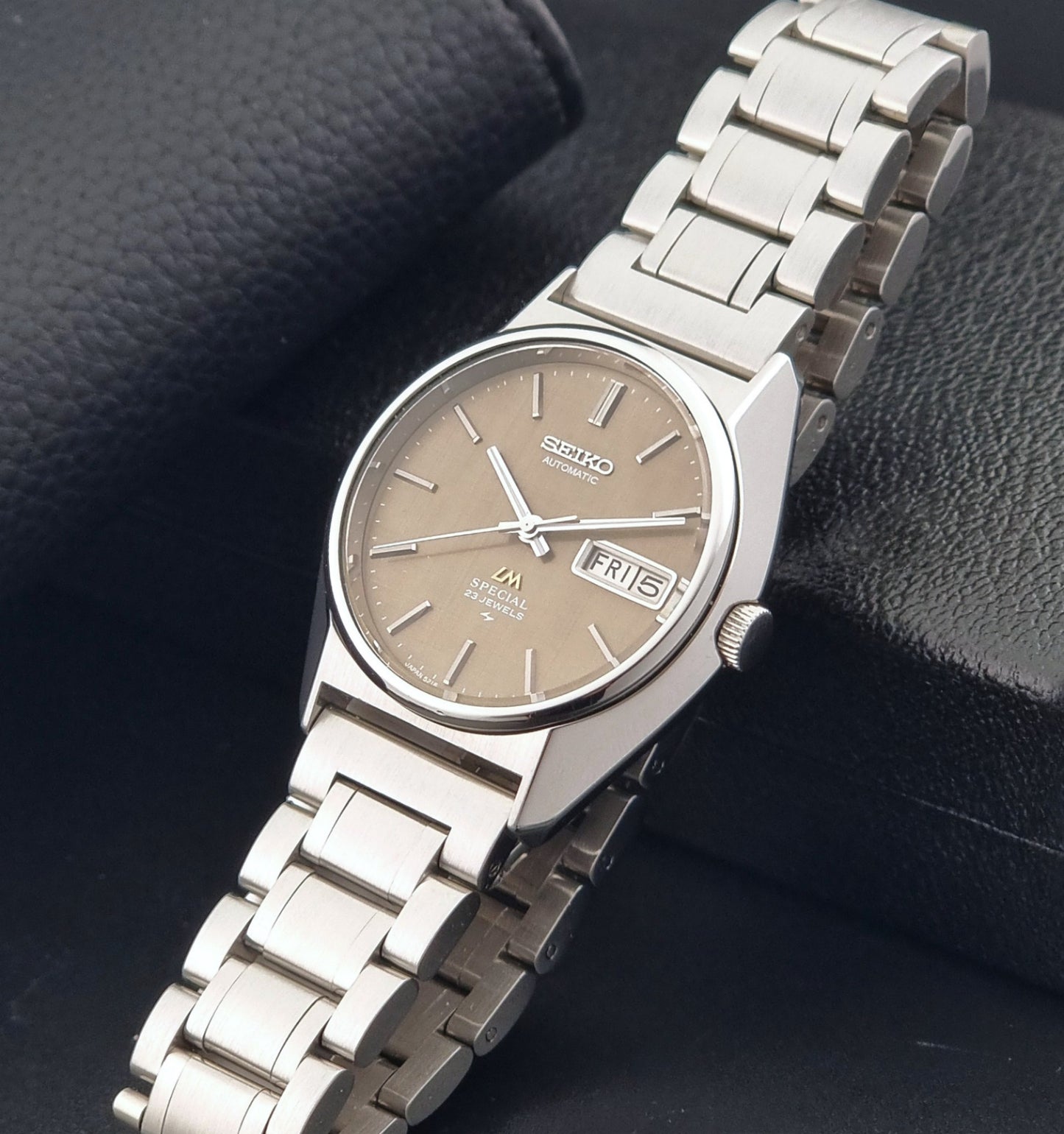 Vintage Seiko Wristwatch LordMatic Special 5216-8020 with a brown dial on a dark gray background crown view