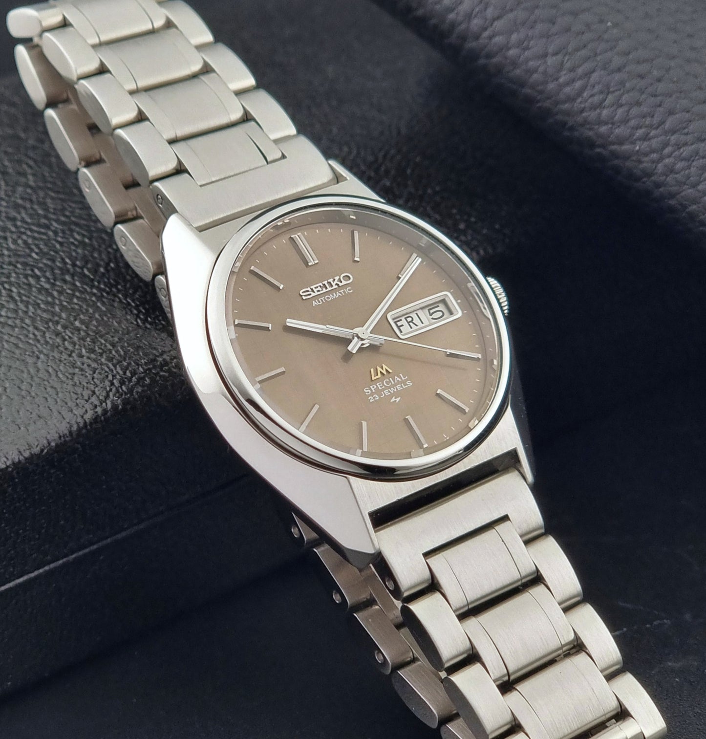 Vintage Seiko Wristwatch LordMatic Special 5216-8020 with a brown dial on a dark gray background side view