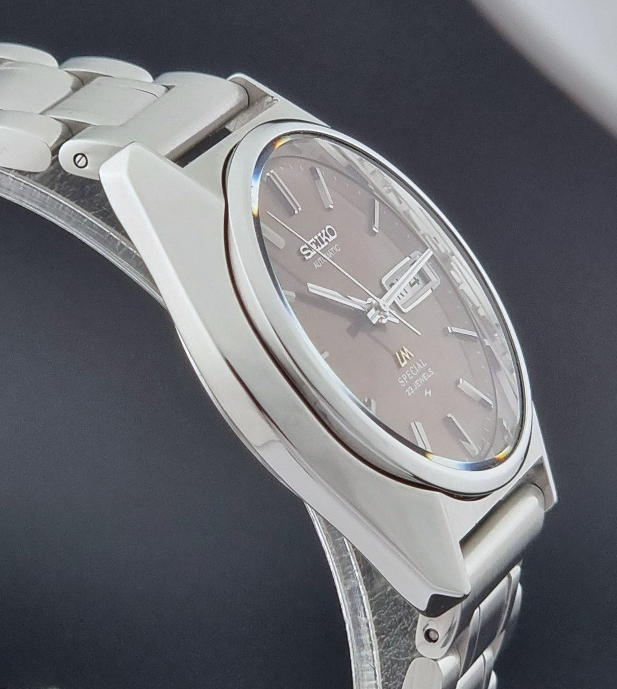 Vintage Seiko Wristwatch LordMatic Special 5216-8020 with a brown dial on a dark gray background side profile view