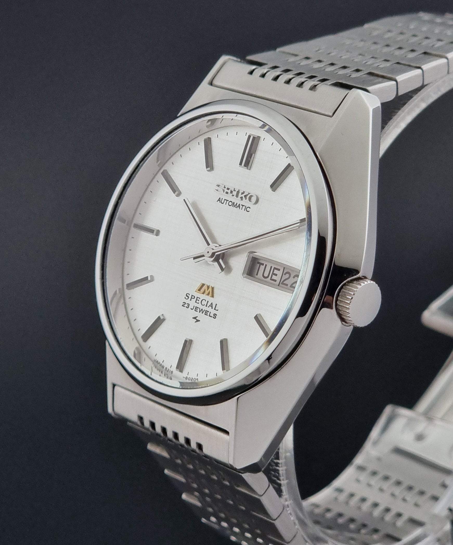Vintage Seiko LordMatic Special 5216-8020 wristwatch wristwatch with a white face on a dark gray background crown profile view