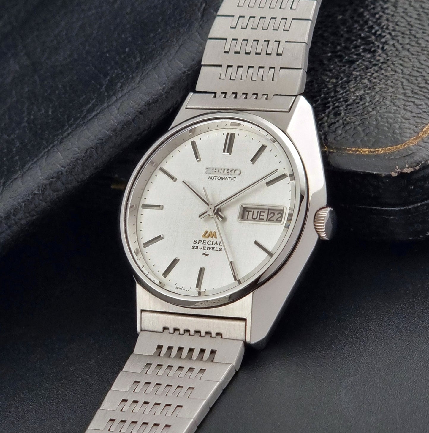 Vintage Seiko LordMatic Special 5216-8020 wristwatch wristwatch with a white face on a dark gray background crown view