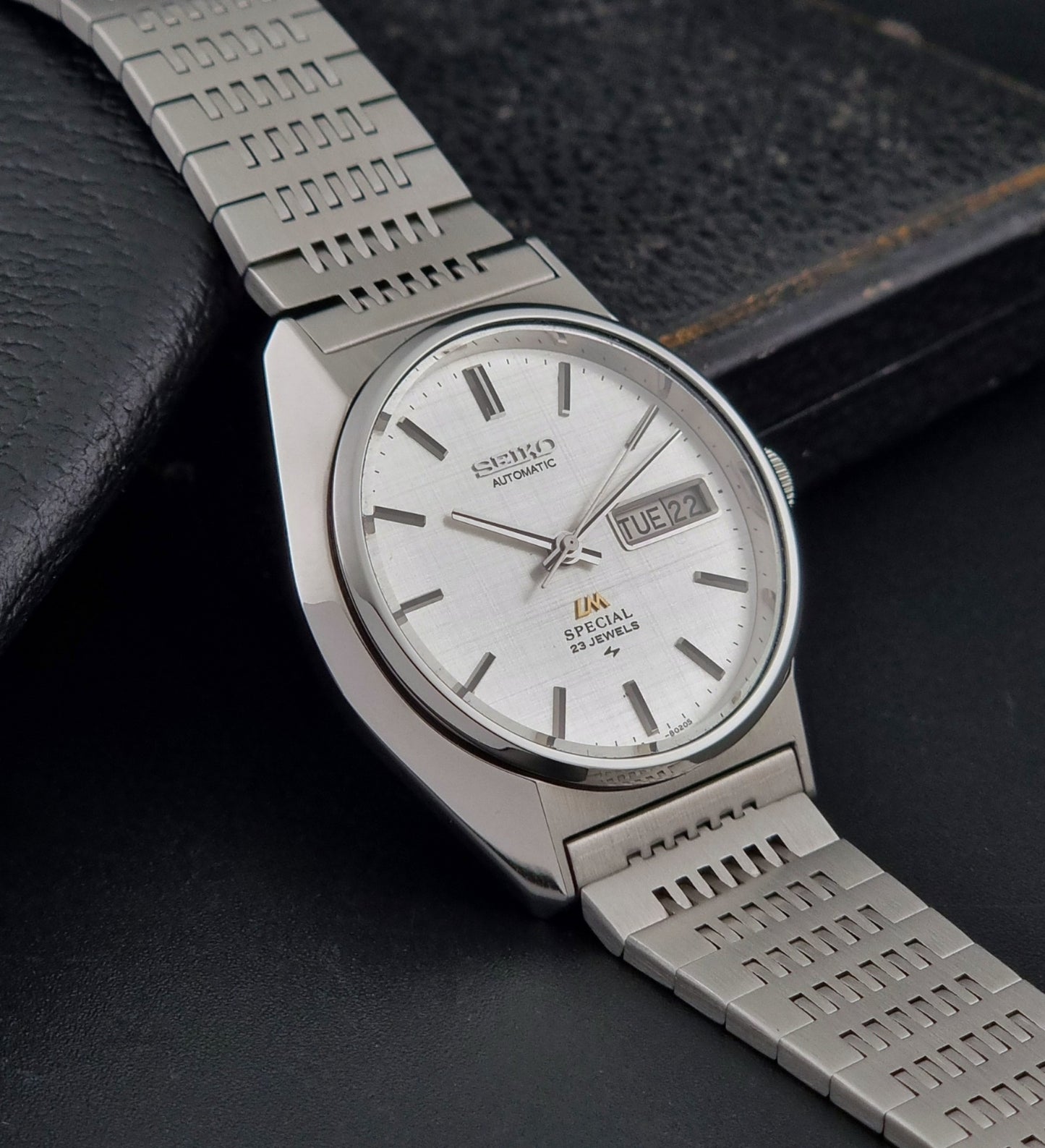 Vintage Seiko LordMatic Special 5216-8020 wristwatch wristwatch with a white face on a dark gray background side view