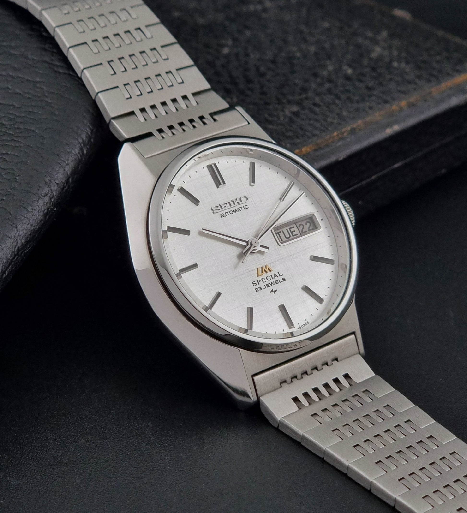 Vintage Seiko LordMatic Special 5216-8020 wristwatch wristwatch with a white face on a dark gray background side view
