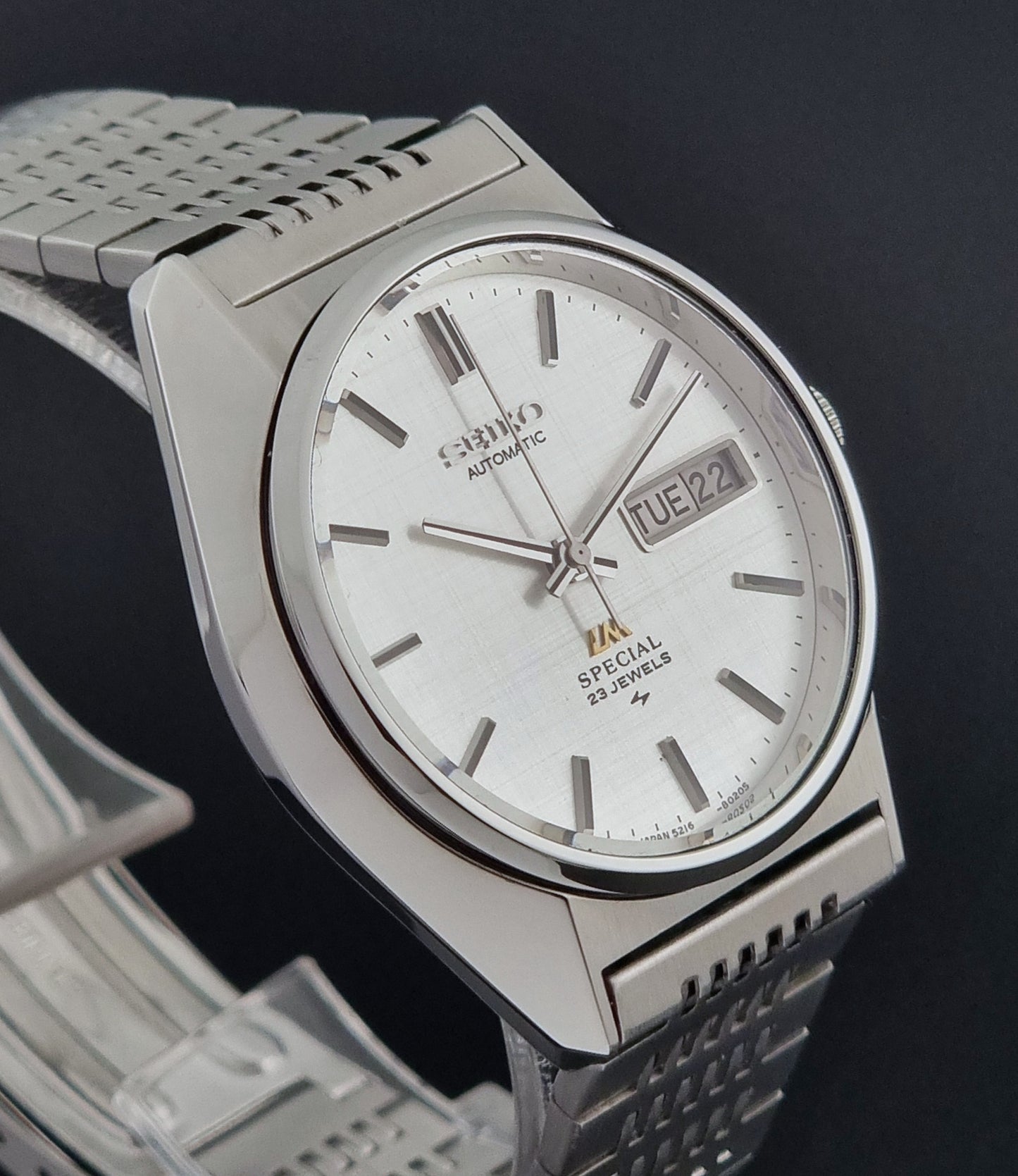 Vintage Seiko LordMatic Special 5216-8020 wristwatch wristwatch with a white face on a dark gray background side profile view