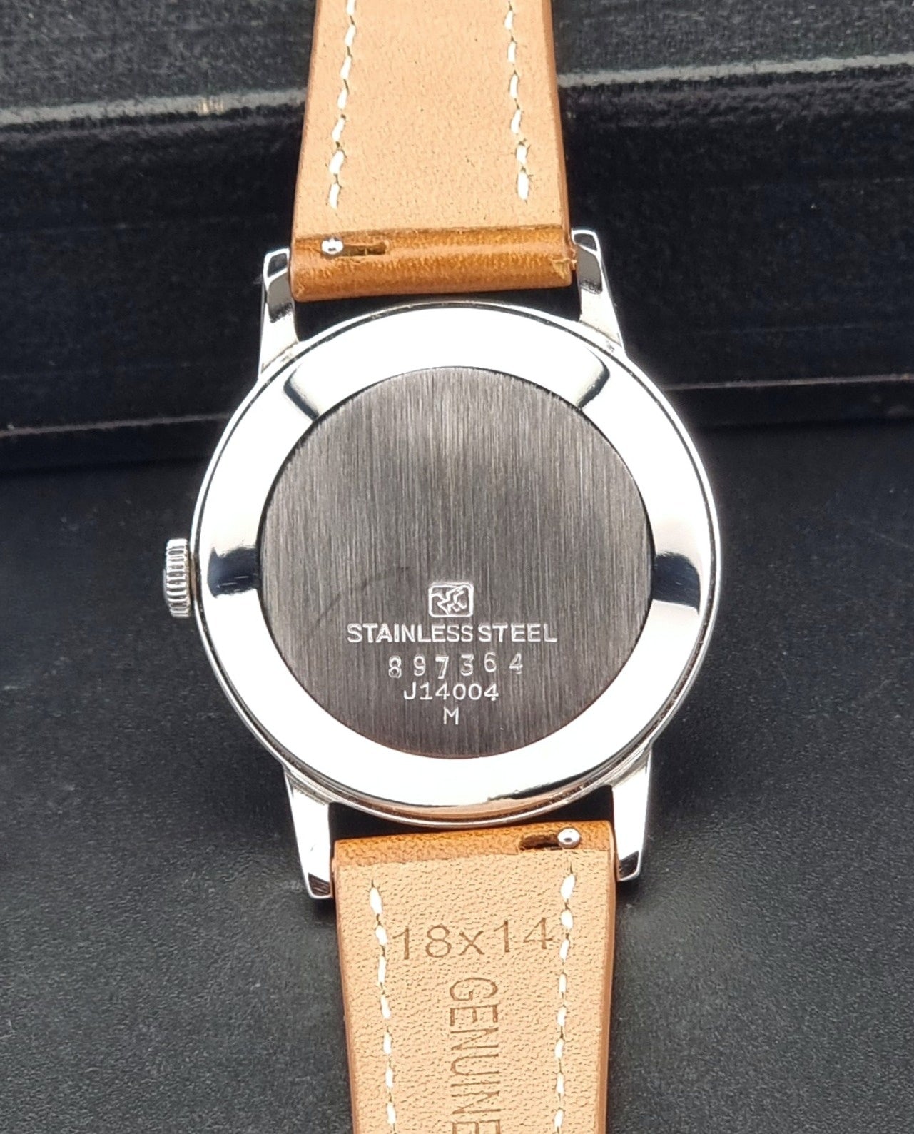 Vintage Seiko Marvel J14004 watch with a brown leather strap on a dark background caseback view