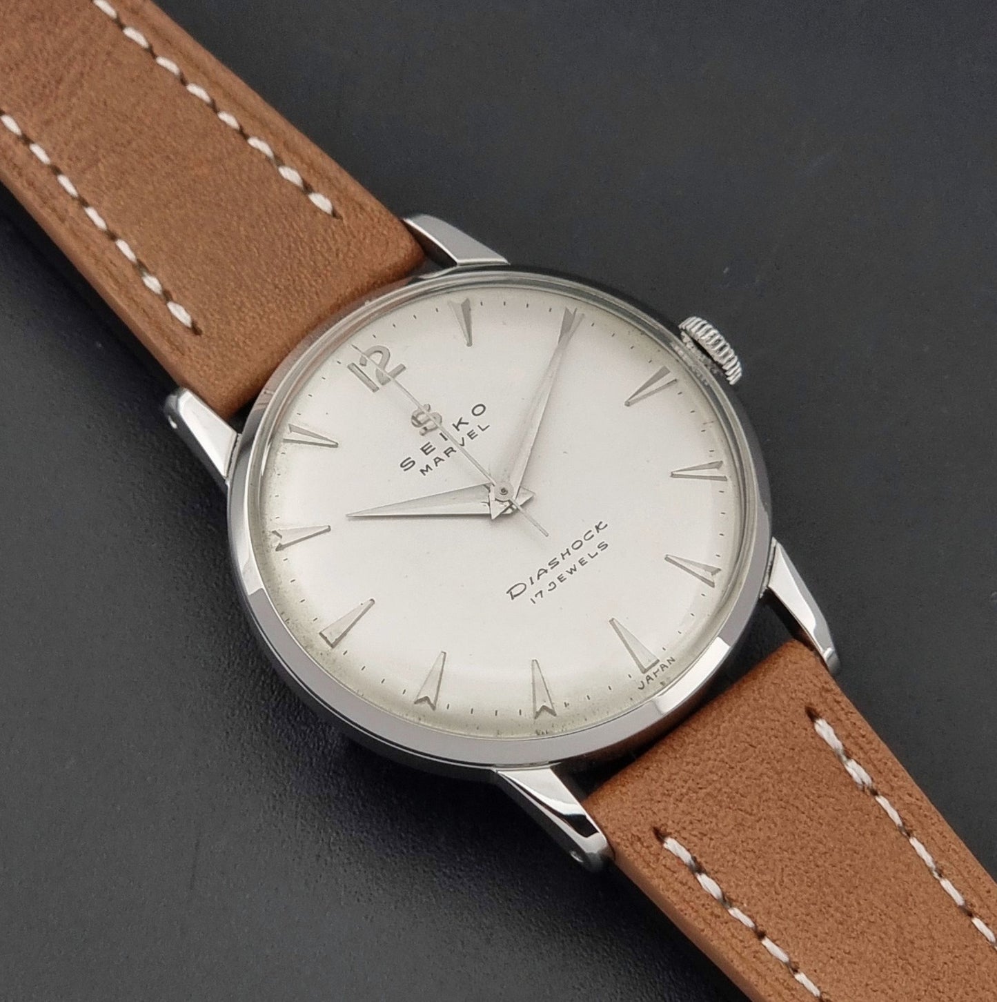 Vintage Seiko Marvel J14004 watch with a brown leather strap on a dark background close up dial view