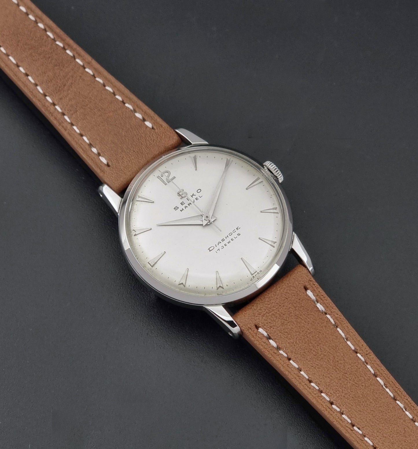 Vintage Seiko Marvel J14004 watch with a brown leather strap on a dark background dial