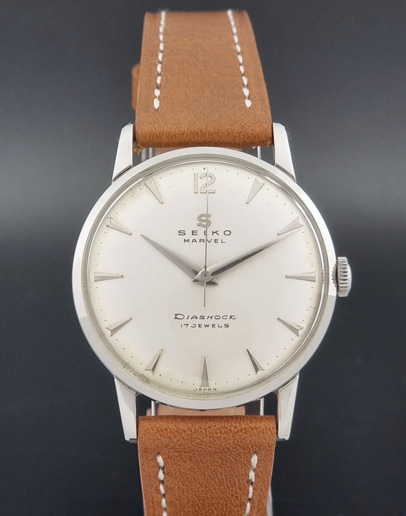 Vintage Seiko Marvel J14004 watch with a brown leather strap on a dark background close dial view