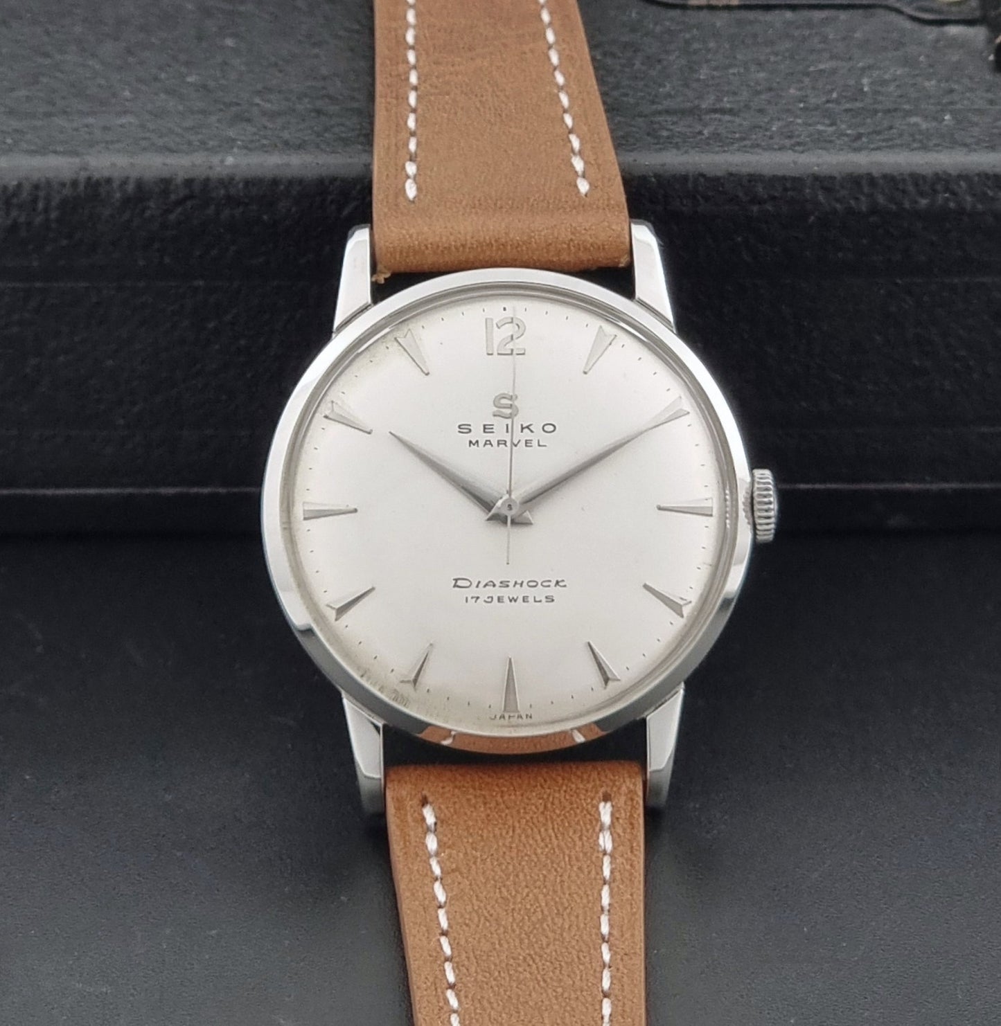 Vintage Seiko Marvel J14004 watch with a brown leather strap on a dark background dial view
