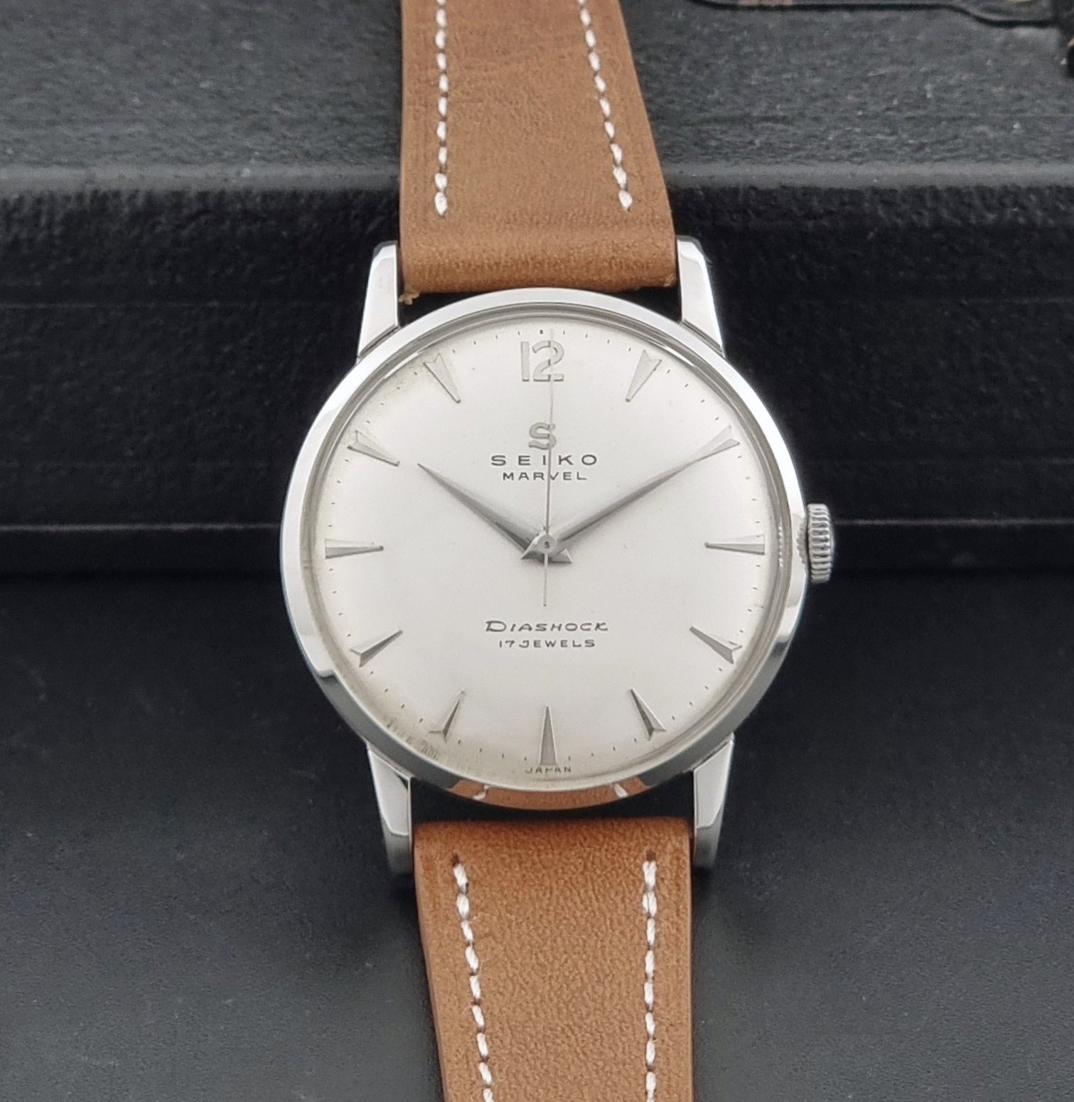Vintage Seiko Marvel J14004 watch with a brown leather strap on a dark background dial view