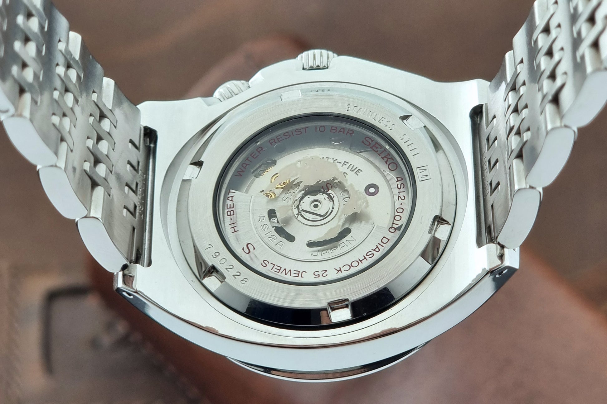 Seiko watch Mechasus SCFF005 GMT 4S12-0010 with a black dial on a gray background case back view