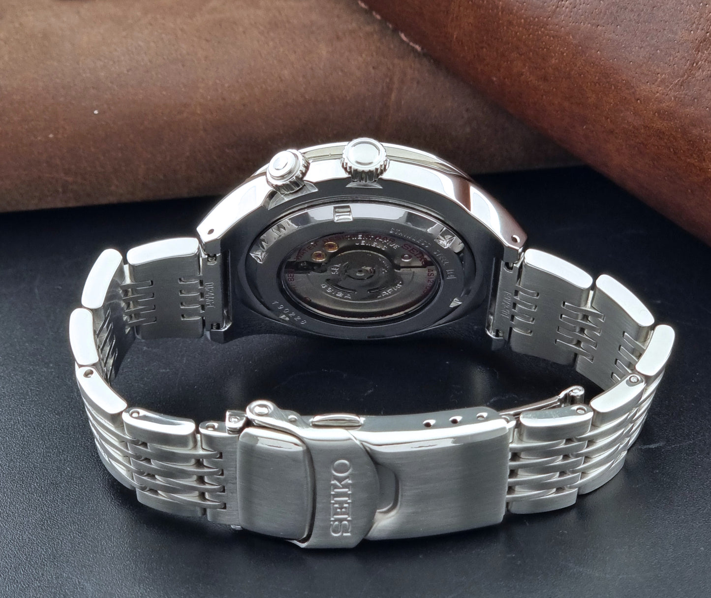 Seiko watch Mechasus SCFF005 GMT 4S12-0010 with a black dial on a gray background bracelet view