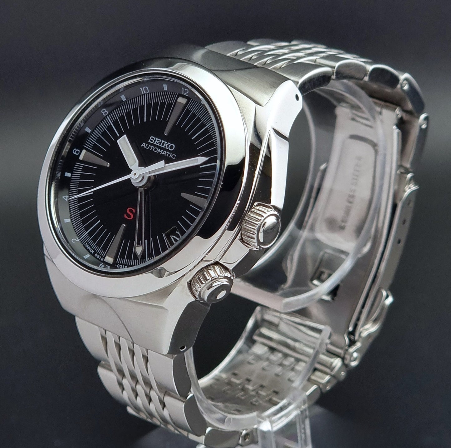 Seiko watch Mechasus SCFF005 GMT 4S12-0010 with a black dial on a gray background crown profile view