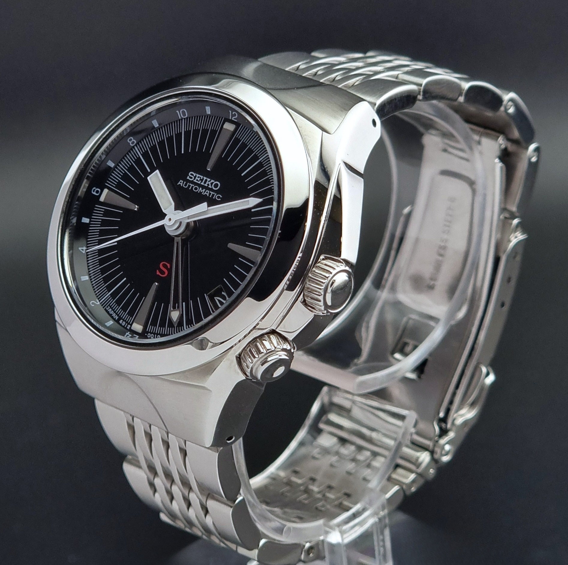 Seiko watch Mechasus SCFF005 GMT 4S12-0010 with a black dial on a gray background crown profile view