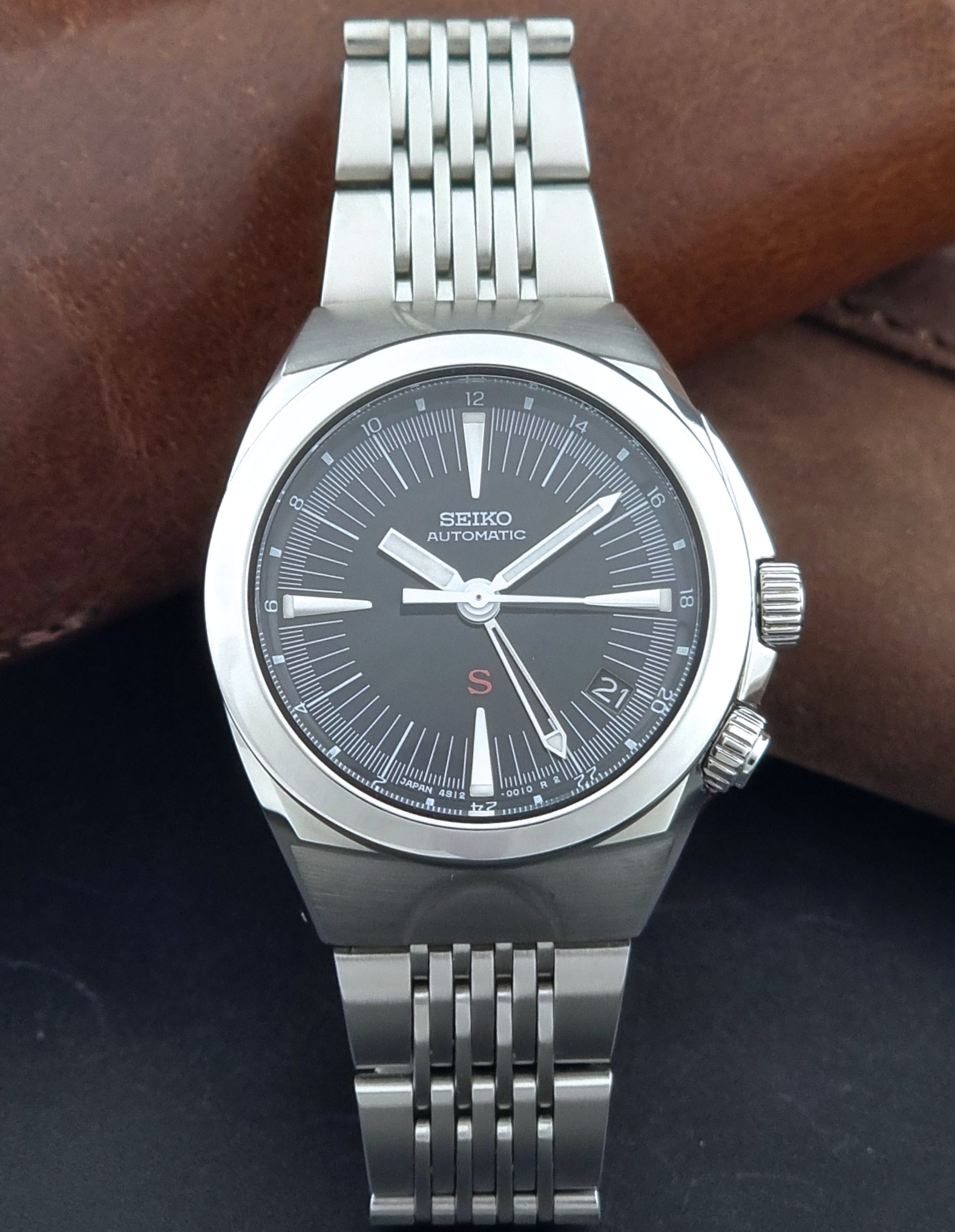 Seiko watch Mechasus SCFF005 GMT 4S12-0010 with a black dial on a gray background dial view