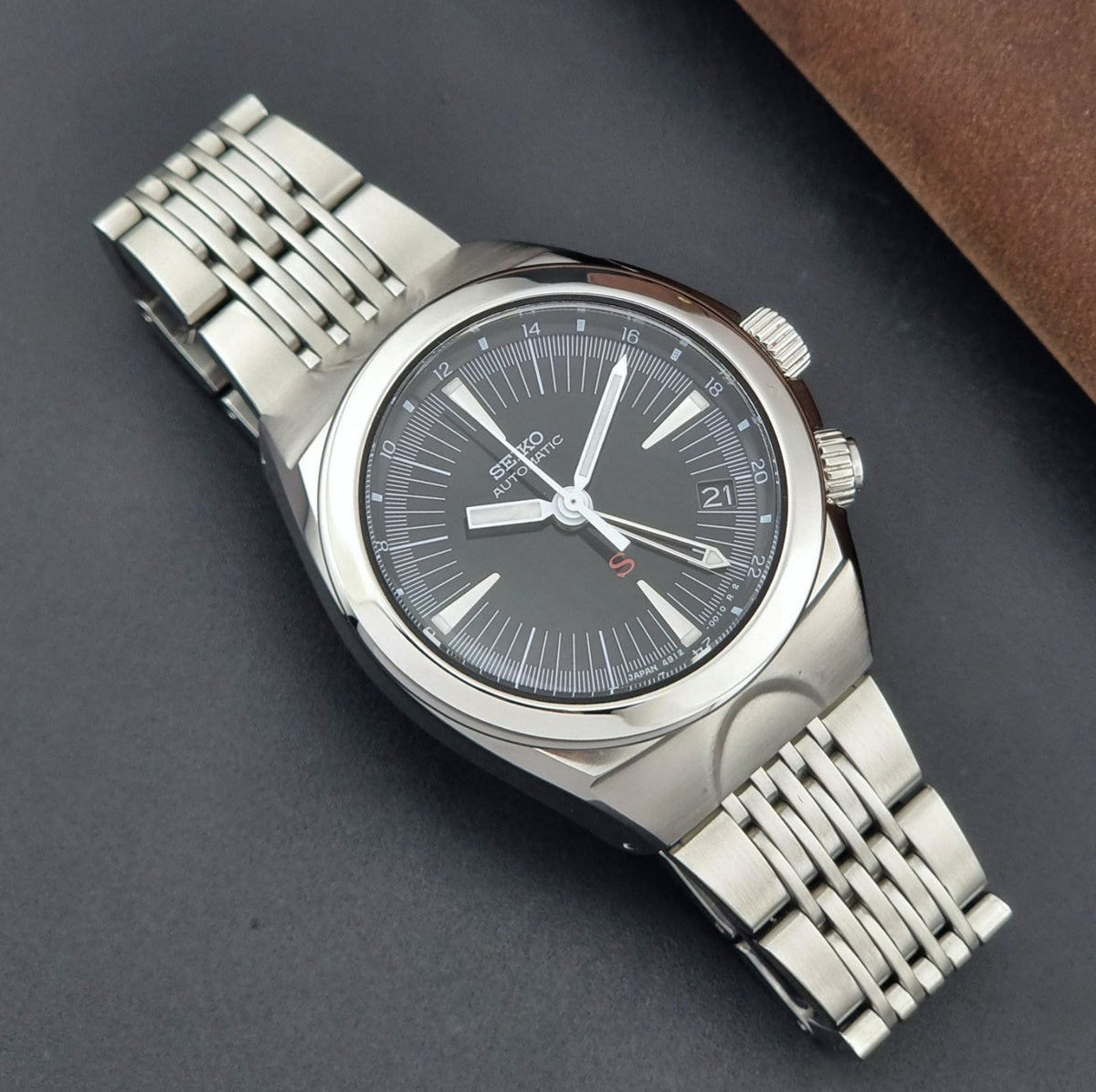 Seiko watch Mechasus SCFF005 GMT 4S12-0010 with a black dial on a gray background dial