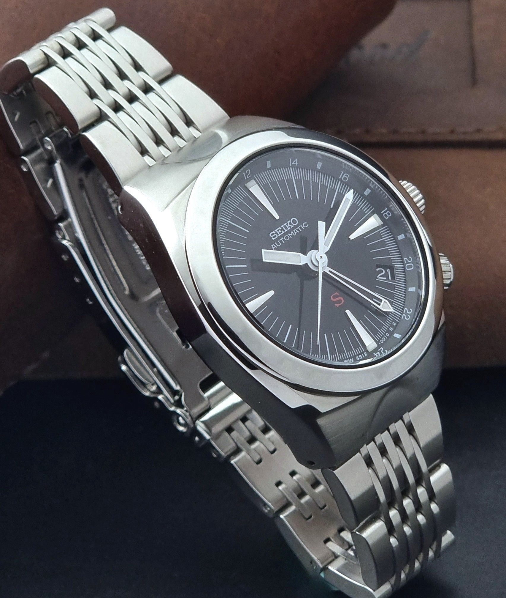 Seiko watch Mechasus SCFF005 GMT 4S12-0010 with a black dial on a gray background side view