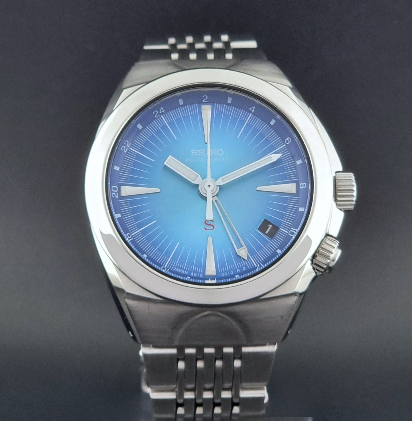 Seiko watch Mechasus SCFF009 GMT 4S12-0010 with a blue face on a dark gray background close dial view