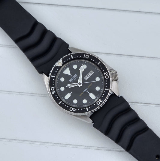 Vintage Seiko Wristwatch 7548-7000 Quartz Diver watch with a rubber strap on a light wooden surface dial