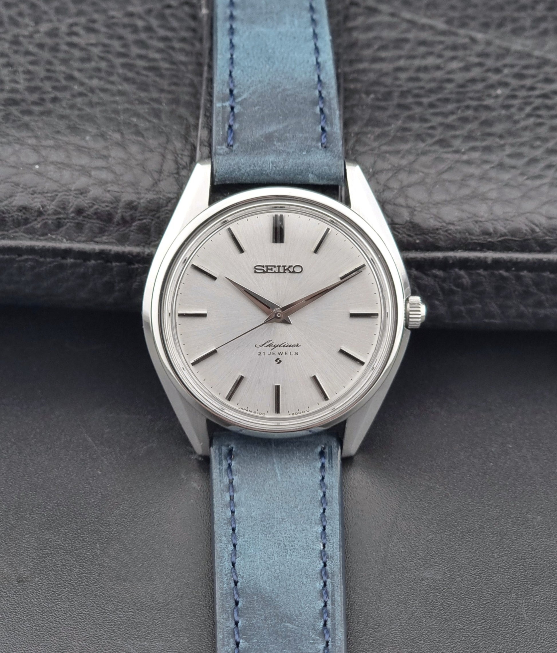 Seiko Skyliner 6100-8000 watch with a blue strap on a gray textured background