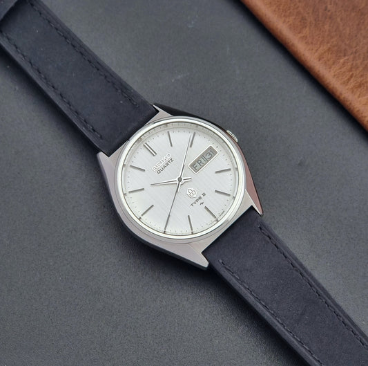 Vintage Seiko Wristwatch 4623-8020 Quartz Type II  with black leather strap on a gray surface dial