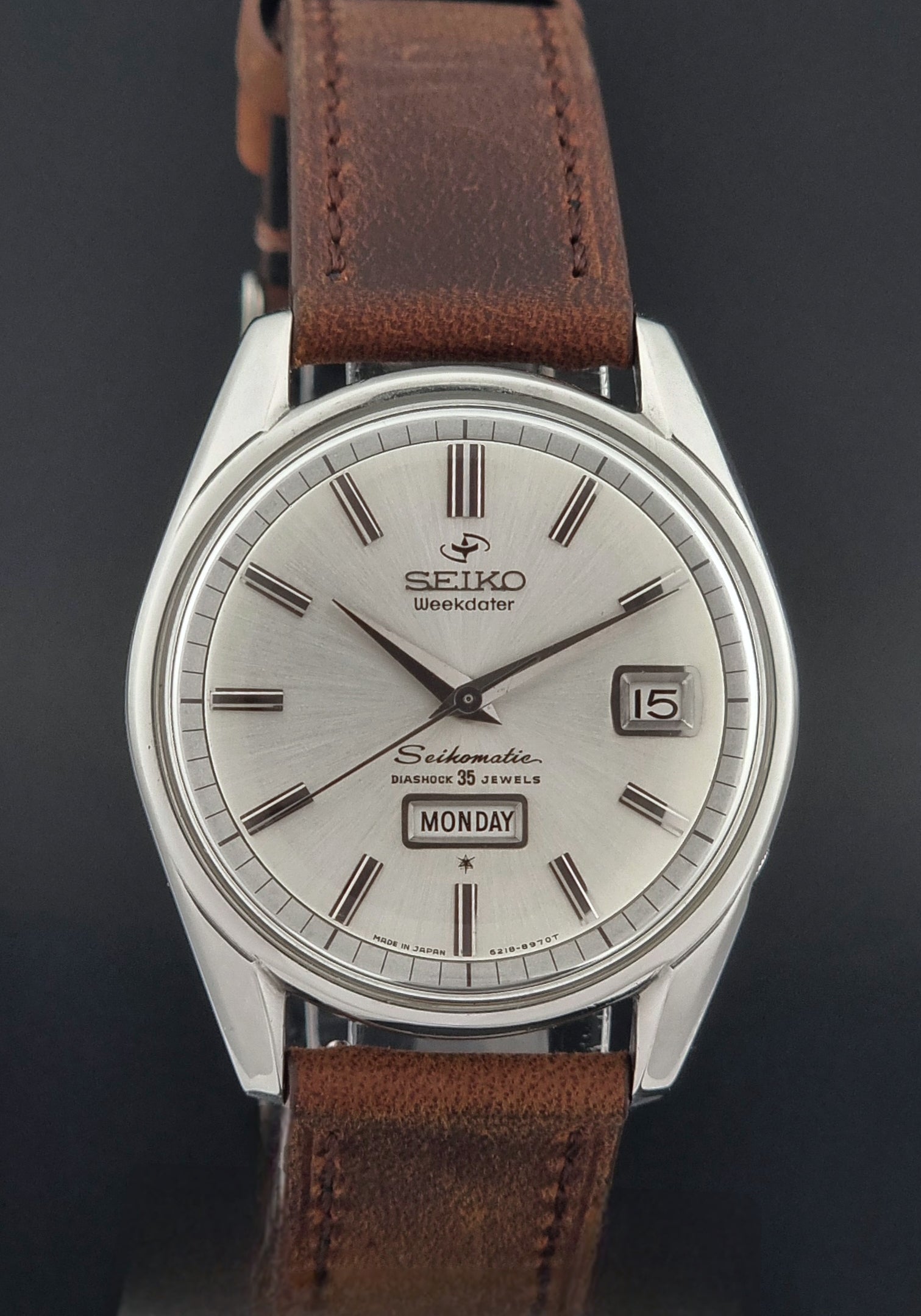 Seiko watch with brown leather strap on a dark background