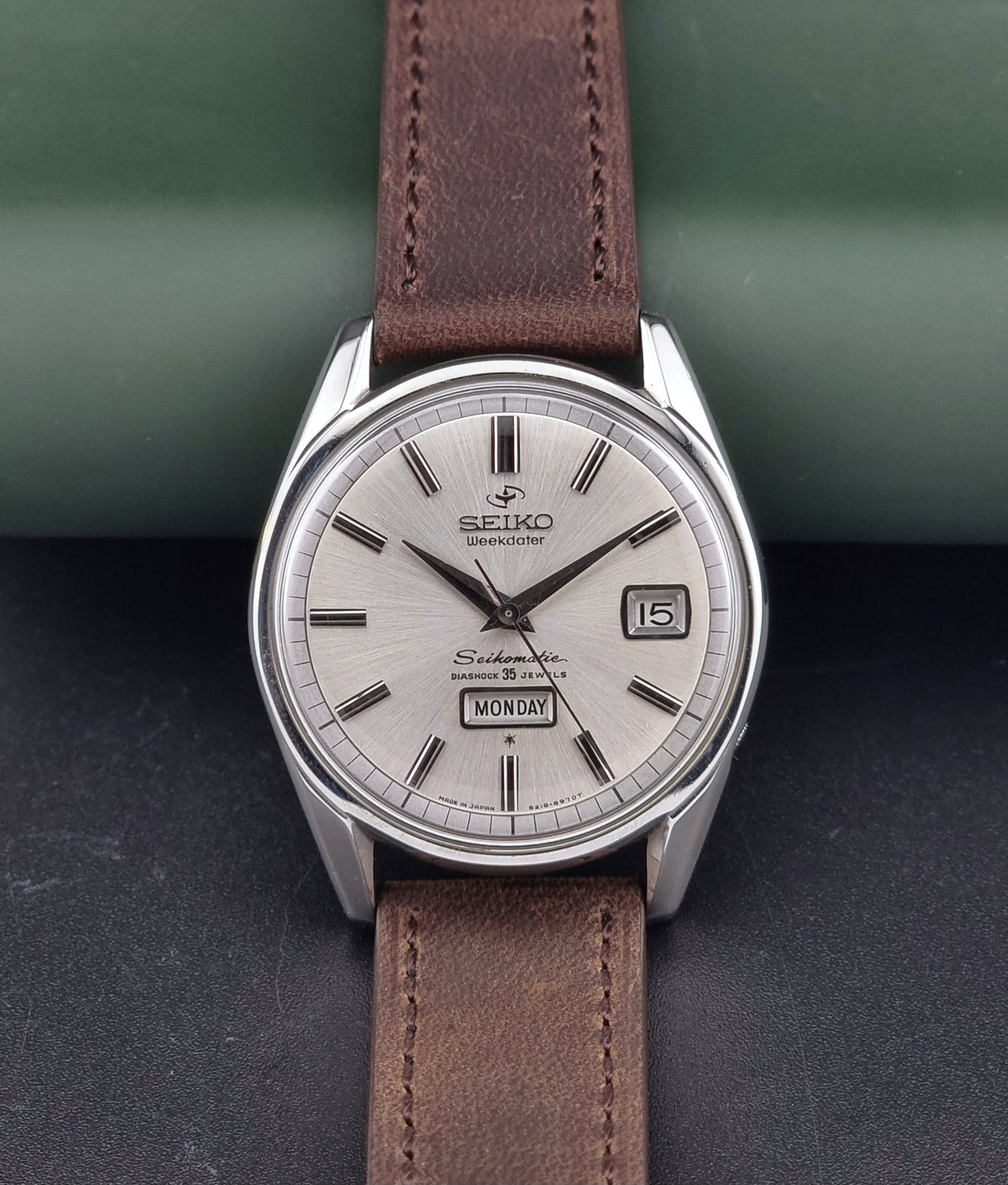 Vintage Seiko watch with brown leather strap on a dark surface