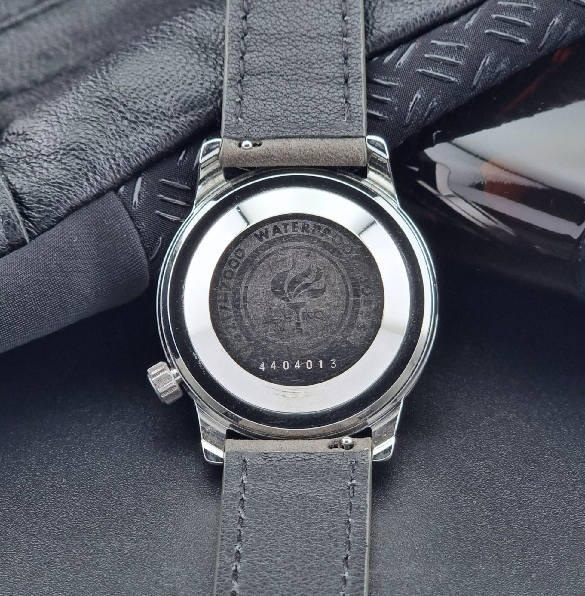 Vintage Seiko Wristwatch World Time 6217-7000 gray leather strap and dark gray dial on a dark background case back