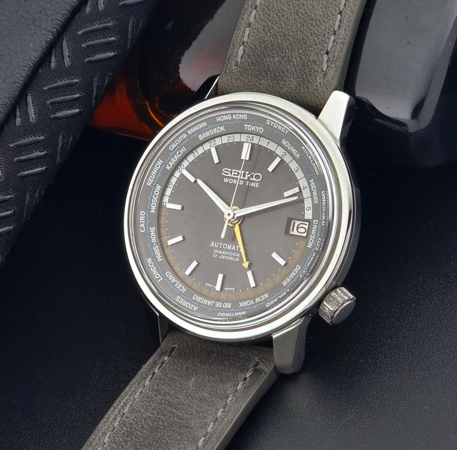 Vintage Seiko Wristwatch World Time 6217-7000 gray leather strap and dark gray dial on a dark background crown view