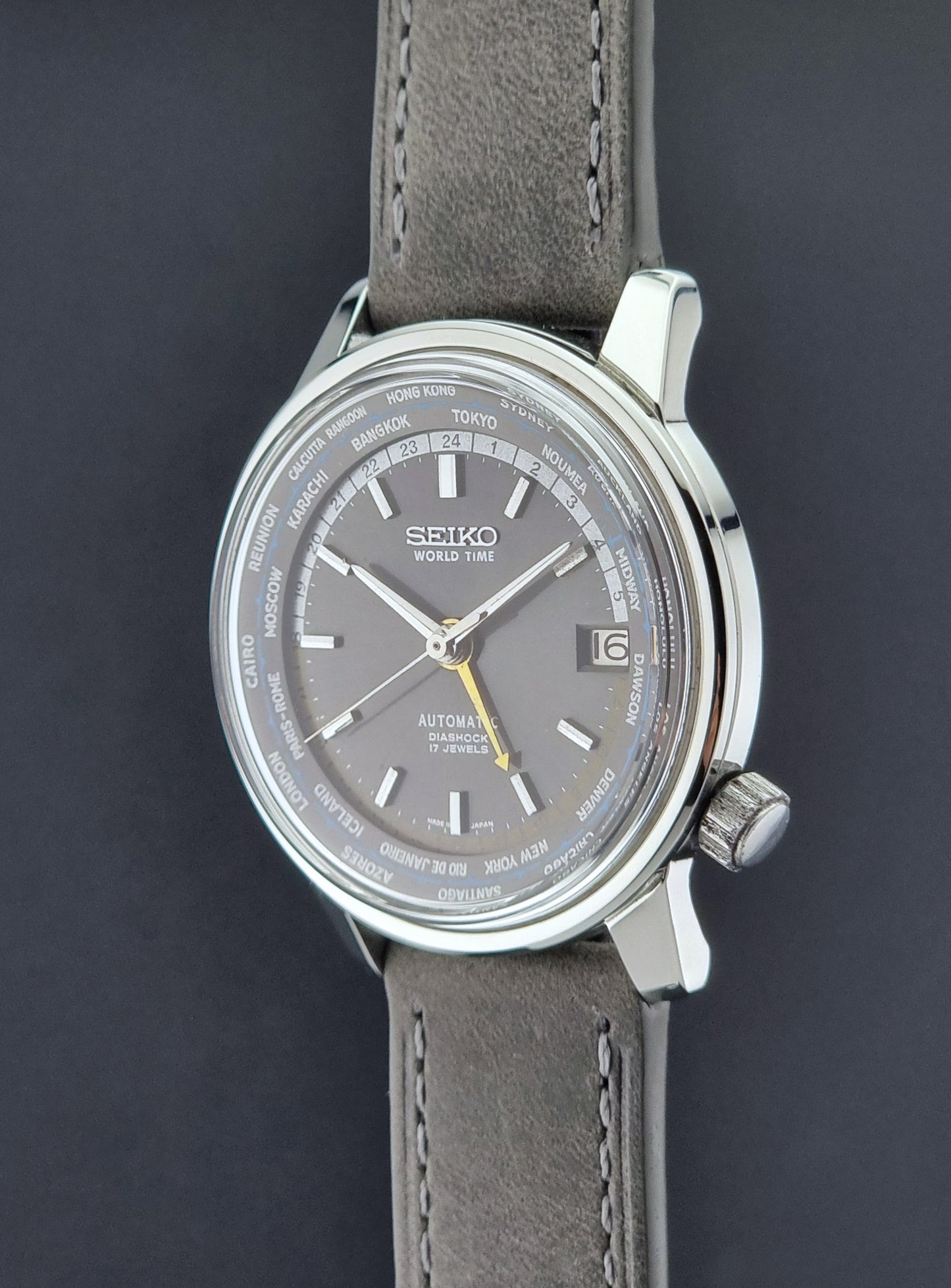 Vintage Seiko Wristwatch World Time 6217-7000 gray leather strap and dark gray dial on a dark background crown side profile
