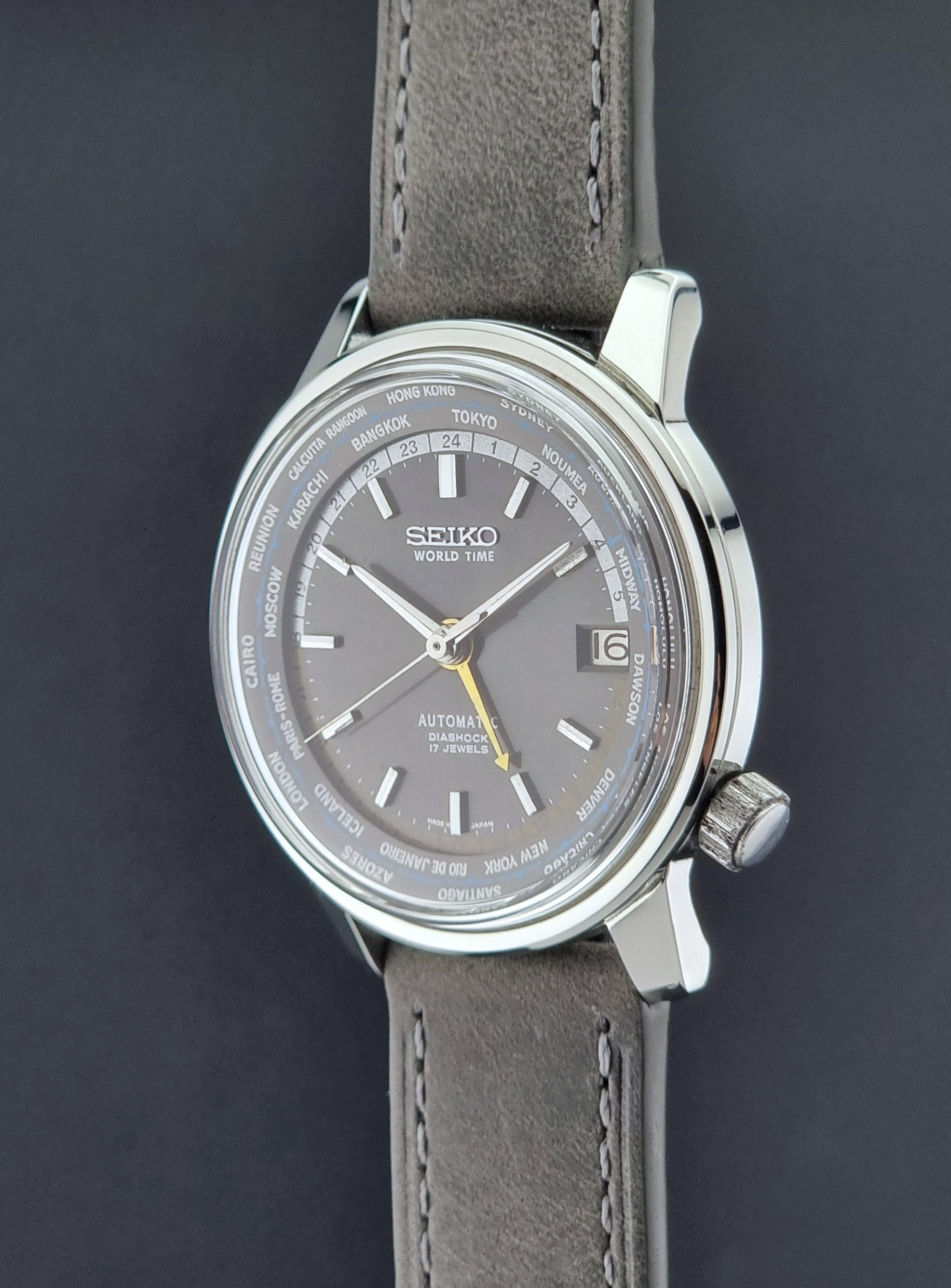 Vintage Seiko Wristwatch World Time 6217-7000 gray leather strap and dark gray dial on a dark background crown side profile