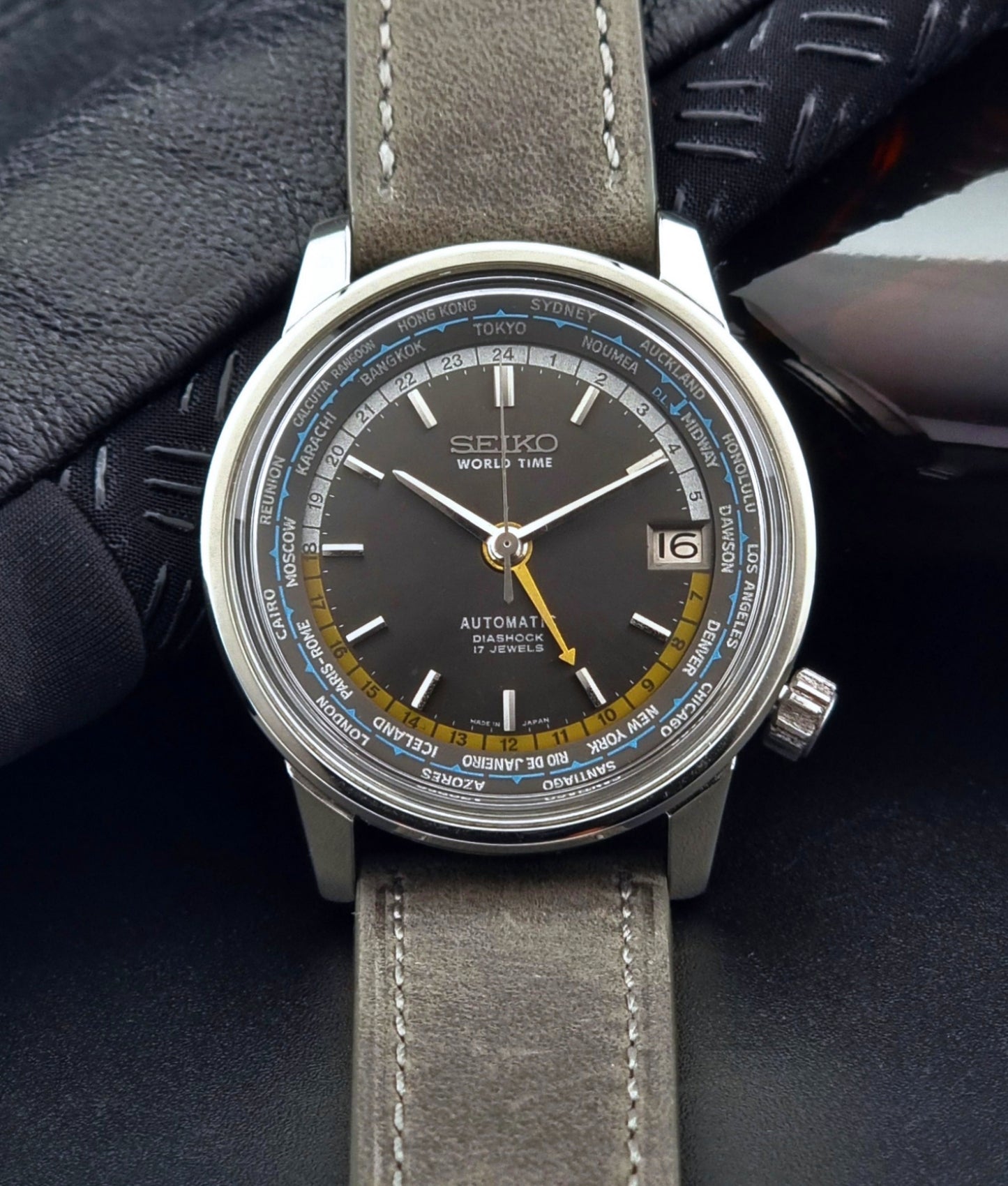 Vintage Seiko Wristwatch World Time 6217-7000 gray leather strap and dark gray dial on a dark background front