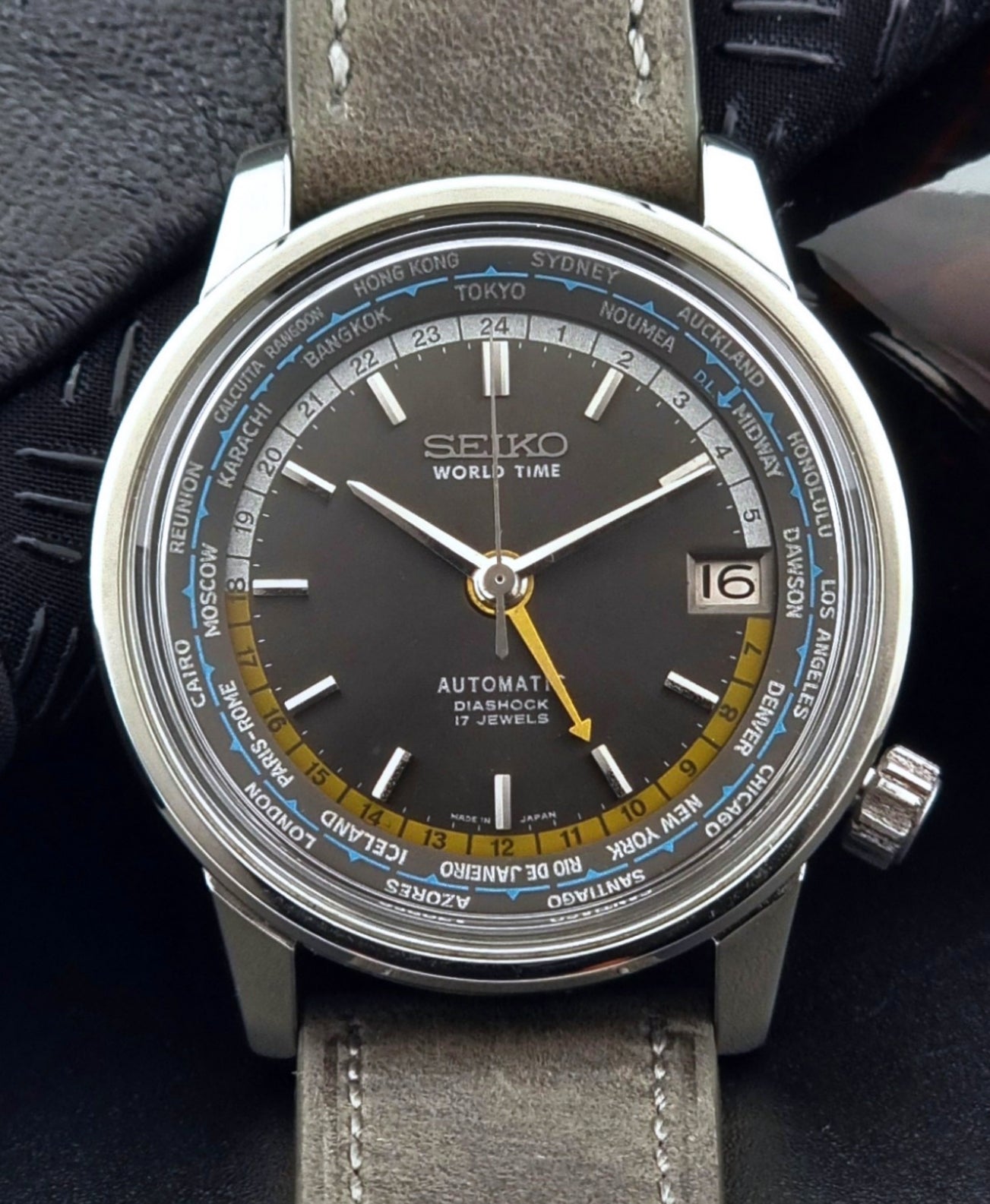 Vintage Seiko Wristwatch World Time 6217-7000 gray leather strap and dark gray dial on a dark background close up  dial view