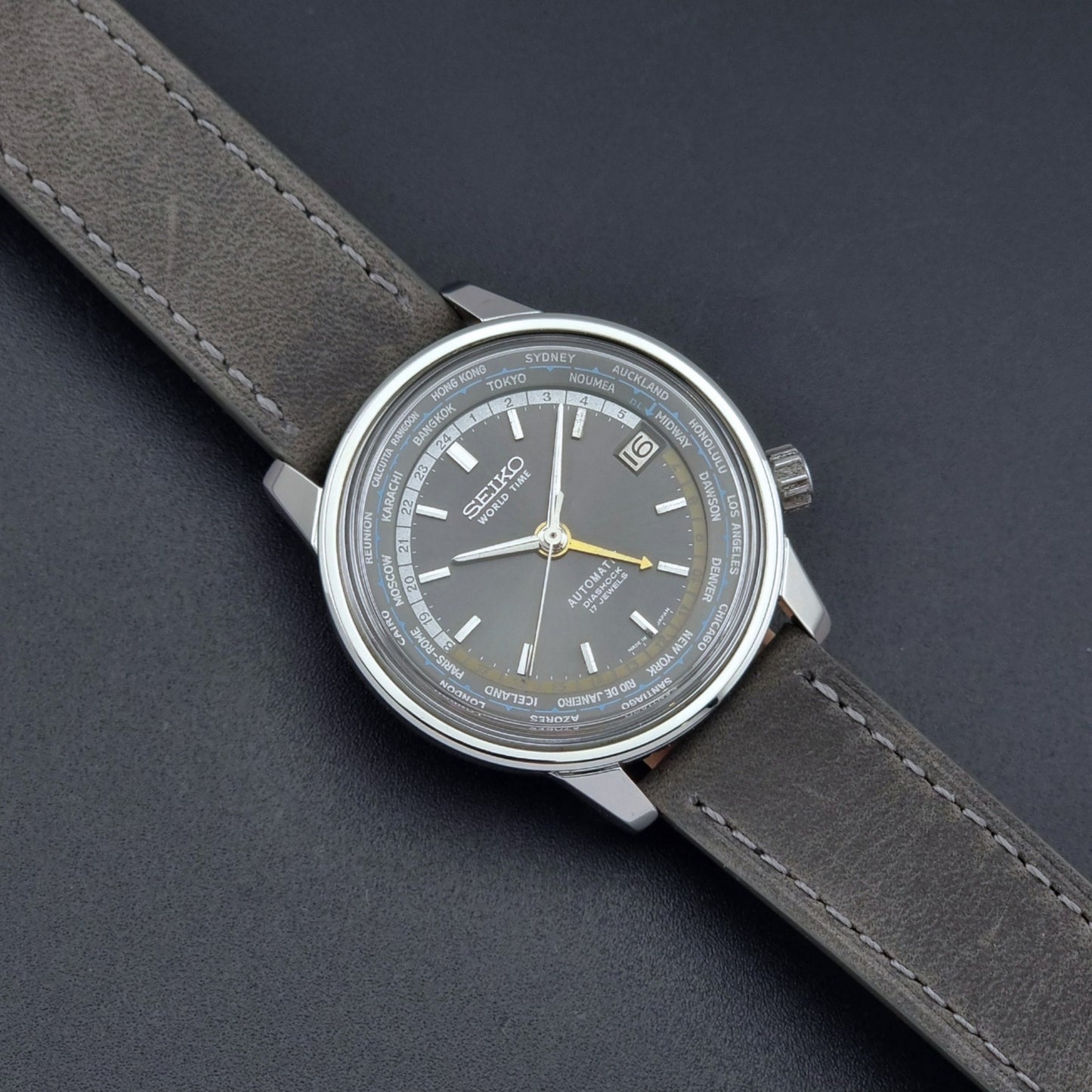 Vintage Seiko Wristwatch World Time 6217-7000 gray leather strap and dark gray dial on a dark background