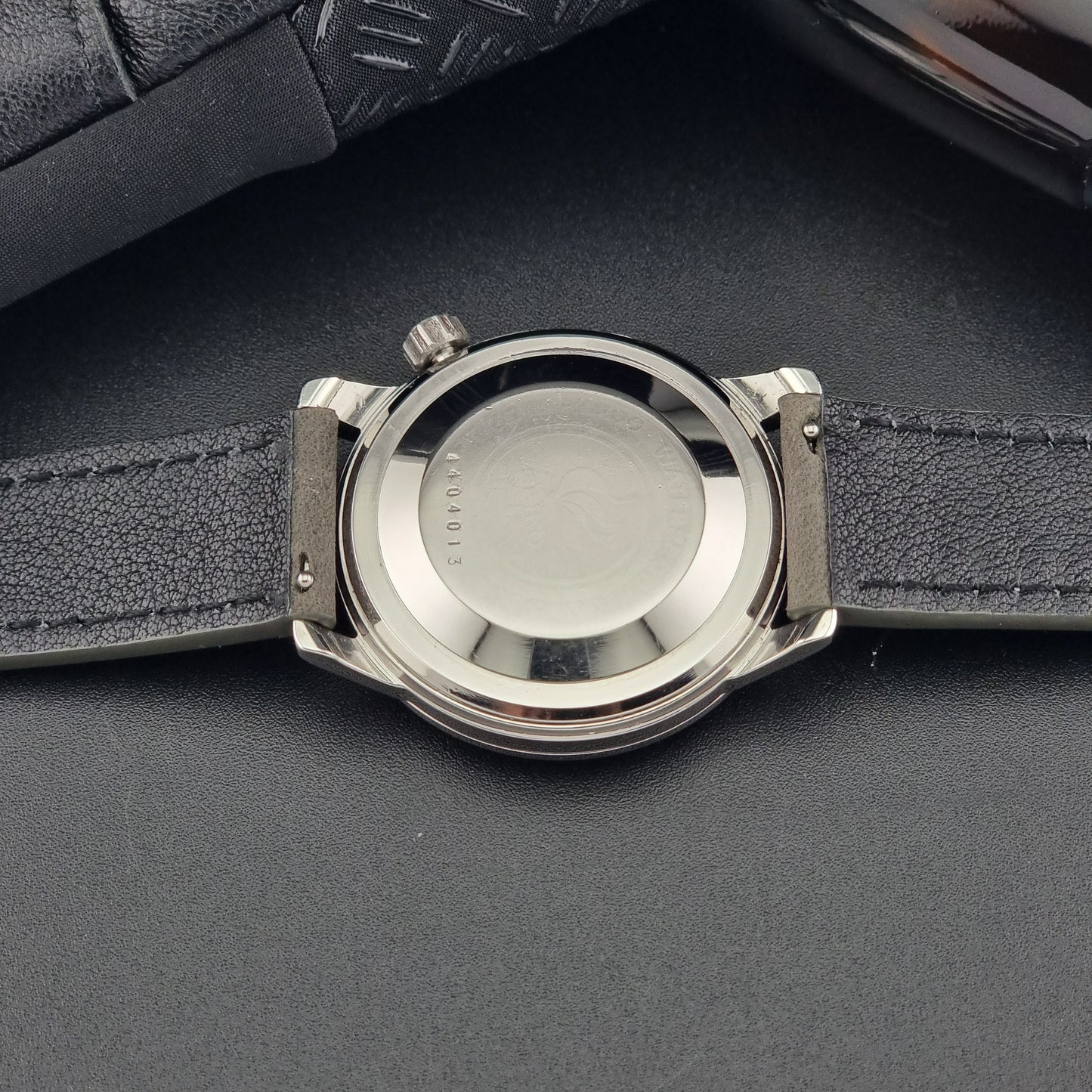 Vintage Seiko Wristwatch World Time 6217-7000 gray leather strap and dark gray dial on a dark background case back close up case back