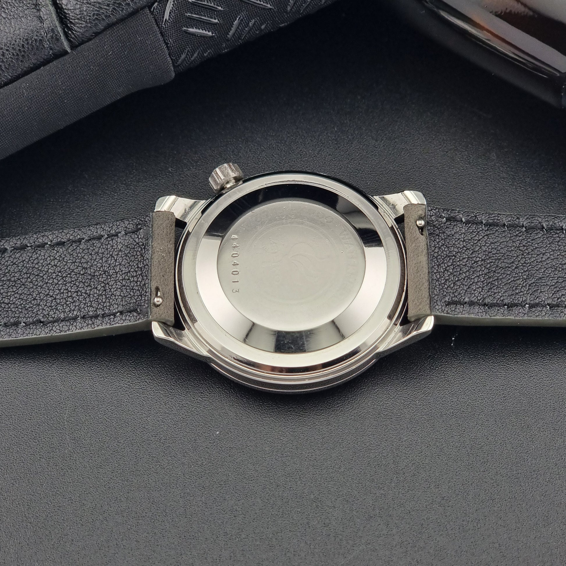 Vintage Seiko Wristwatch World Time 6217-7000 gray leather strap and dark gray dial on a dark background case back close up case back