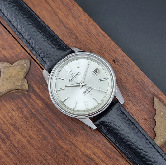 Vintage Seiko Wristwatch Seikomatic J13085 Selfdater with black leather strap on a brown surface dial