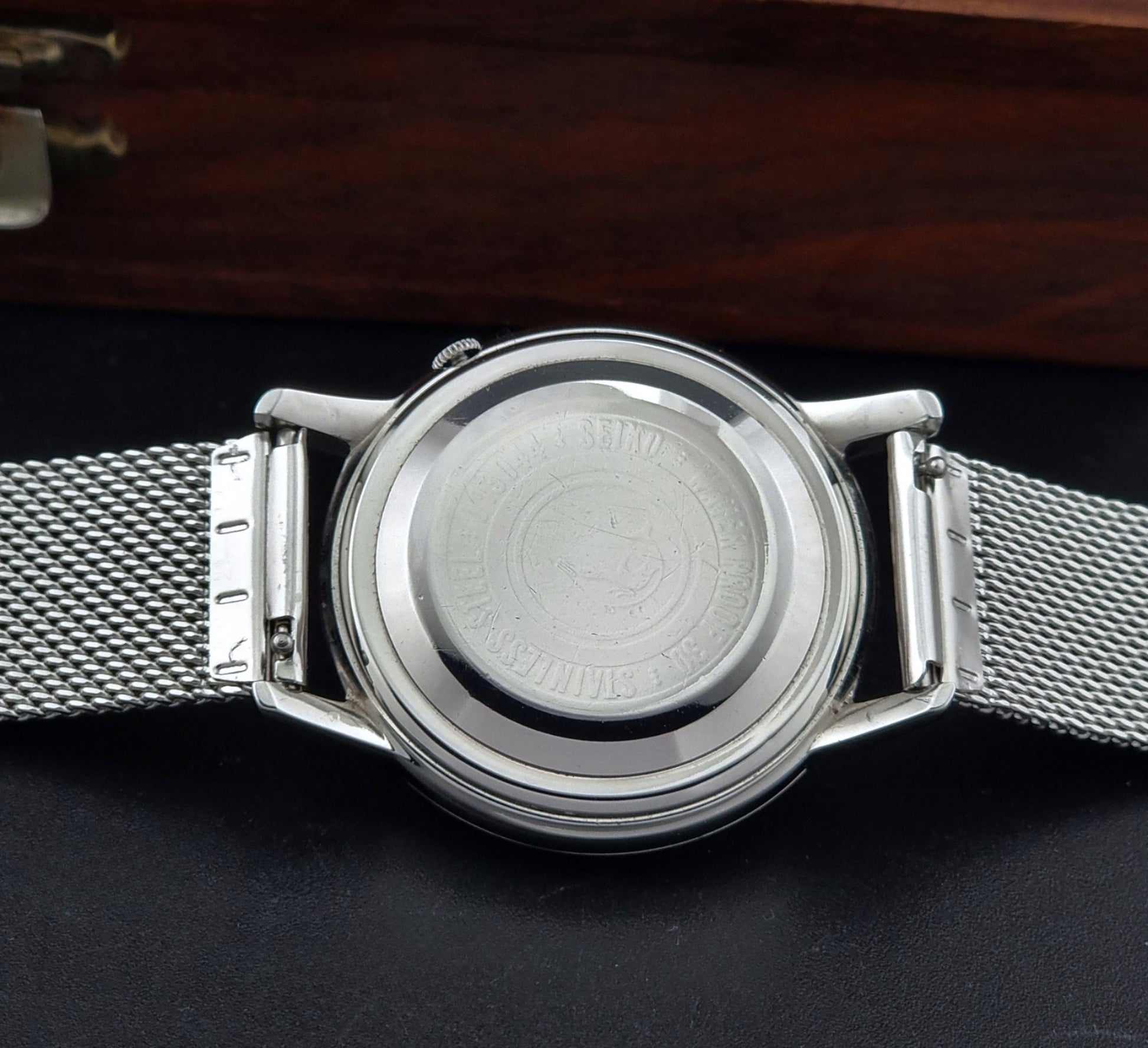 Vintage Seiko Wristwatch Seikomatic J13044E with mesh strap on a dark background case back view